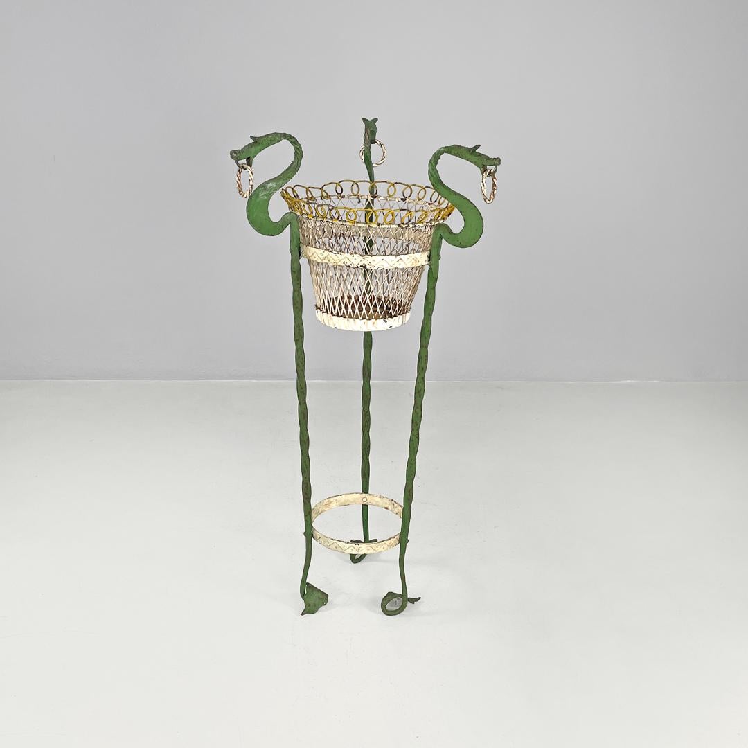 Italian Art Nouveau green wrought iron vase holder with decorative dragons 1900s
Wrought iron plant stand. The structure is made up of three twisted iron bars painted green that end with leaf-shaped feet that extend inwards. The three bars at the