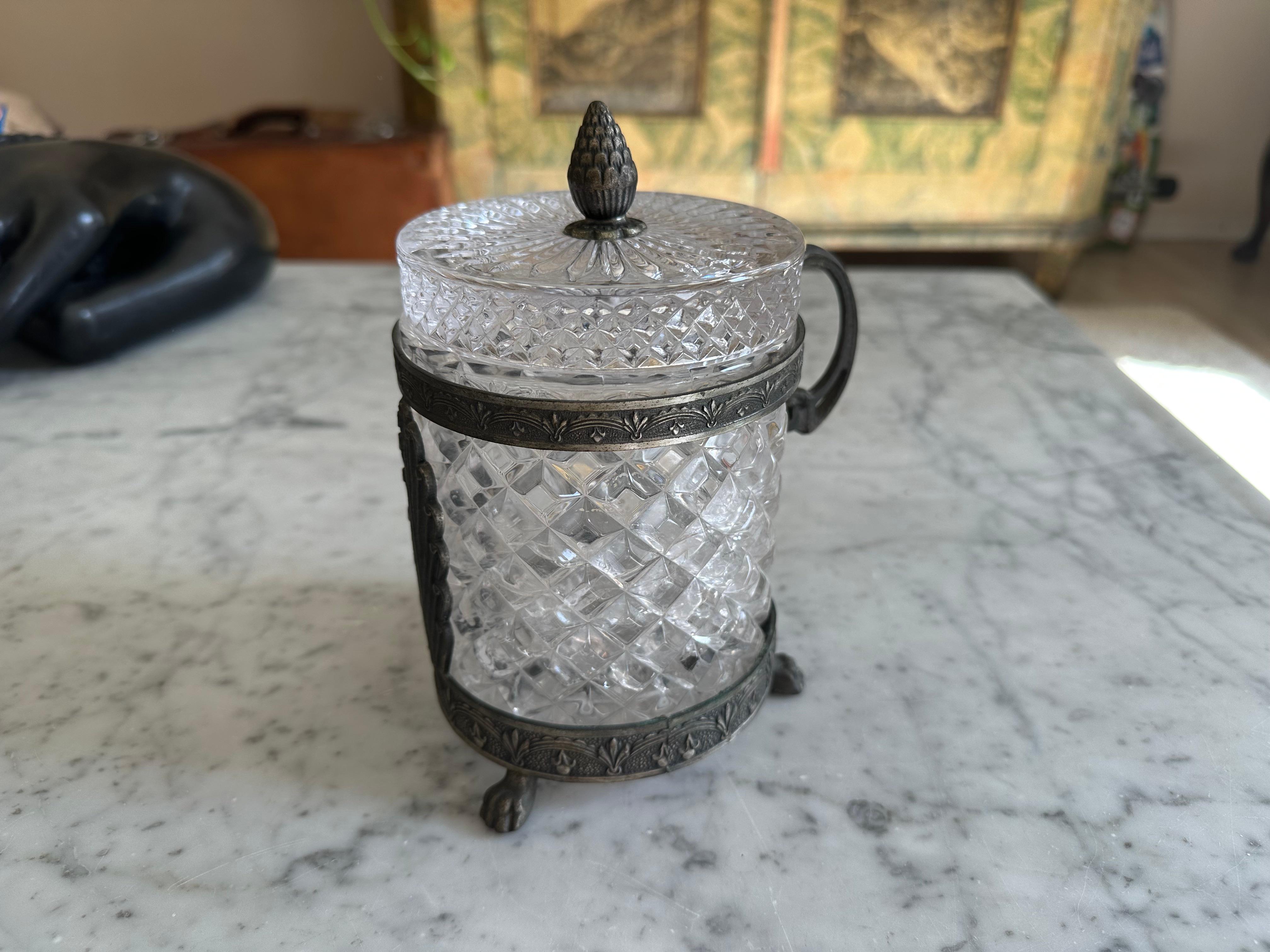 This exquisite lidded jar, which could also serve as a bonbonnière or sugar bowl, is crafted from approximately 1 kilogram of hand-carved rock crystal. The crystal body has been carefully faceted, allowing light to refract and scatter across its