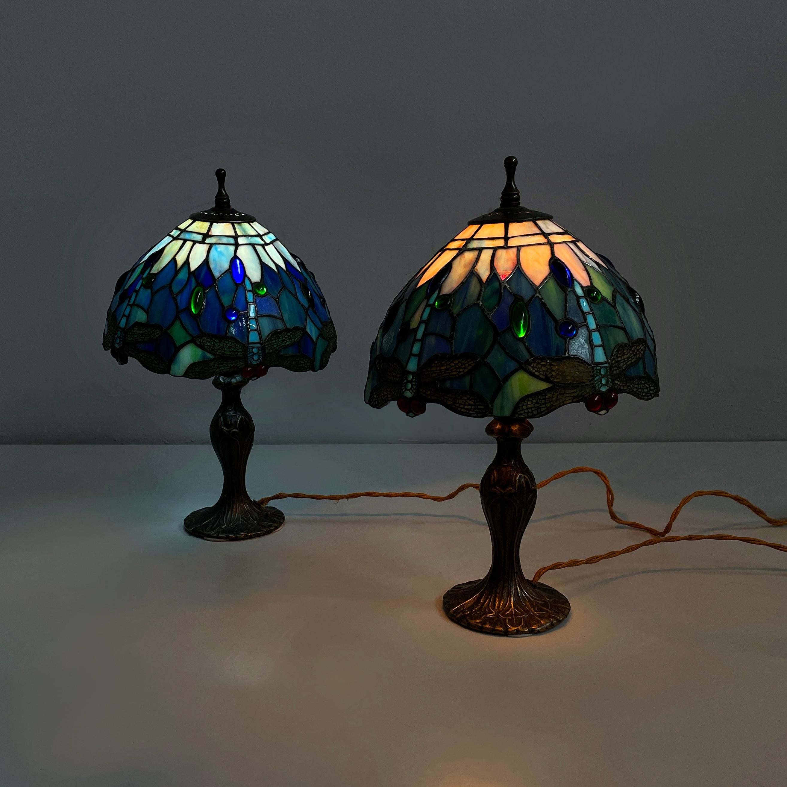 Lampade in stile liberty italiano in vetro colorato e ottone, anni '80
Coppia di lampade da tavolo con paralume in vetro piombato nei colori azzurro, verde e blu. Il paralume presenta decorazioni ellittiche in rilievo e disegni di libellule sul