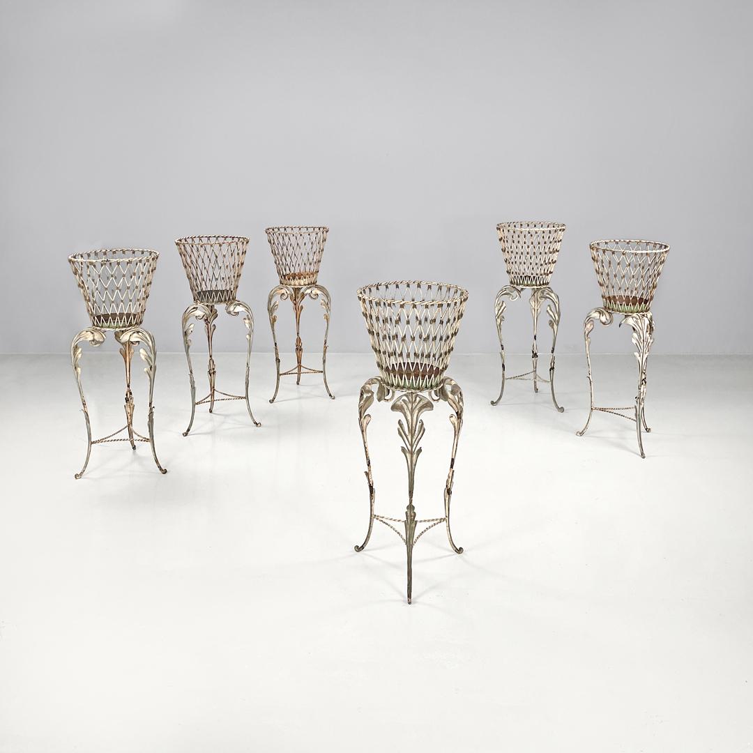 Italian Art Nouveau white wrought iron vase holder with floral decorations 1900s
Set of six wrought iron vase holders painted white whit golden details. The round vase holder is composed of a mesh frame with golden cylindrical details, this part is