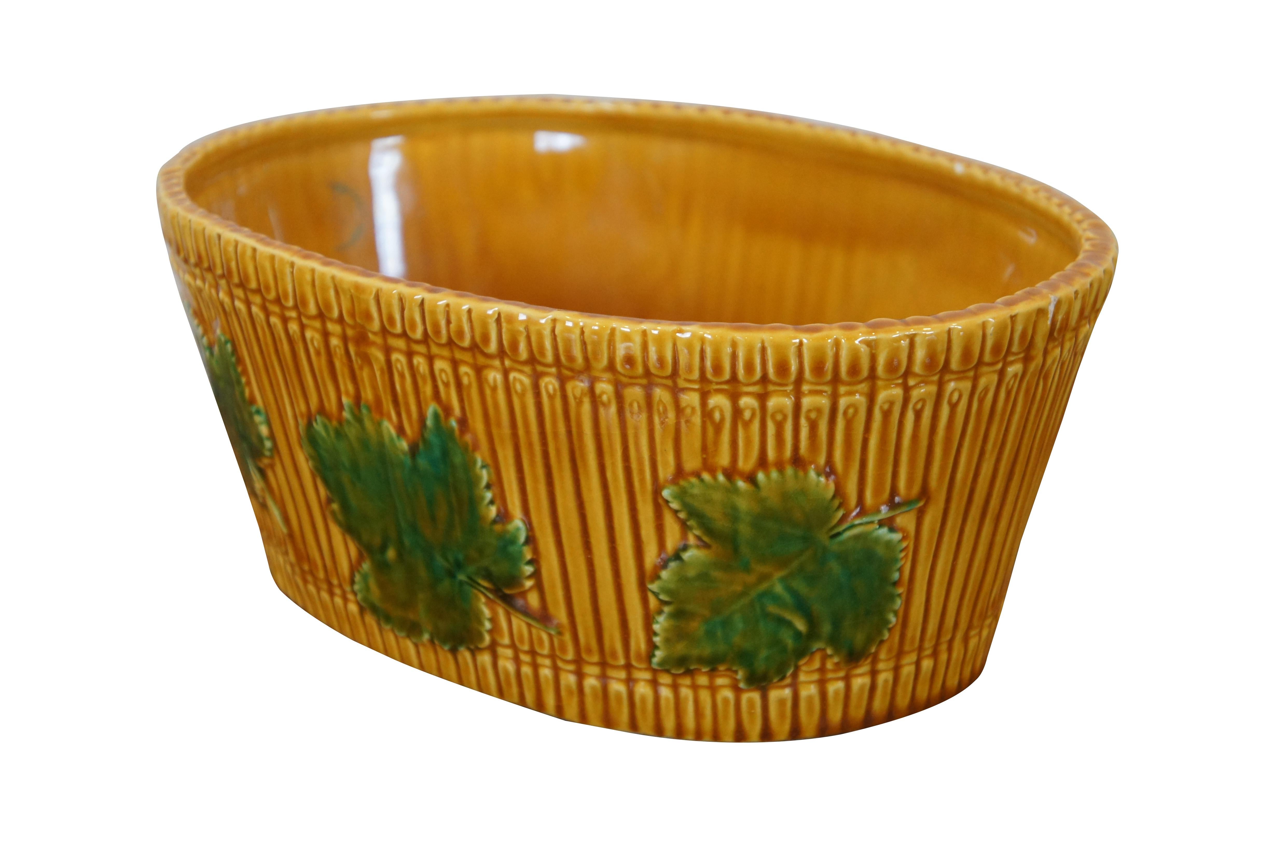 Large vintage Italian art pottery / majolica planter. Oval shape with tapered base; glazed in yellow and brown to resemble a bushel basket, accented with several green grape leaves. Marked S.5941 Italy on base.

Dimensions:
11” x 7.5” x 4.5” (Width