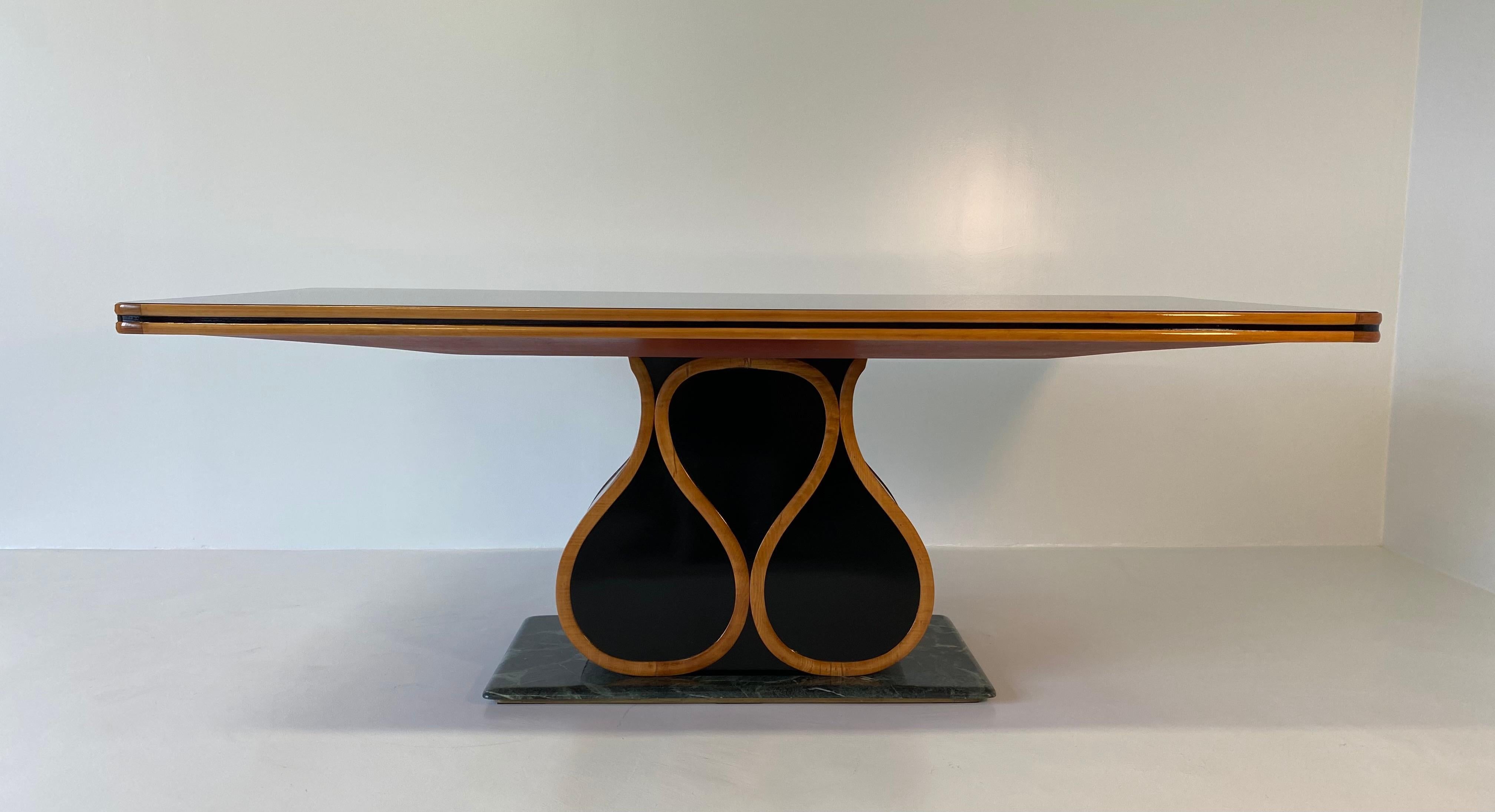 This fine Art Deco table was produced in the 1940s in Cantù (Italy) by Vittorio Dassi for 'Permanente Mobili Cantù'.
The table is in black lacquered wood with profiles and decorations in solid maple wood.
The top is in original black glass while