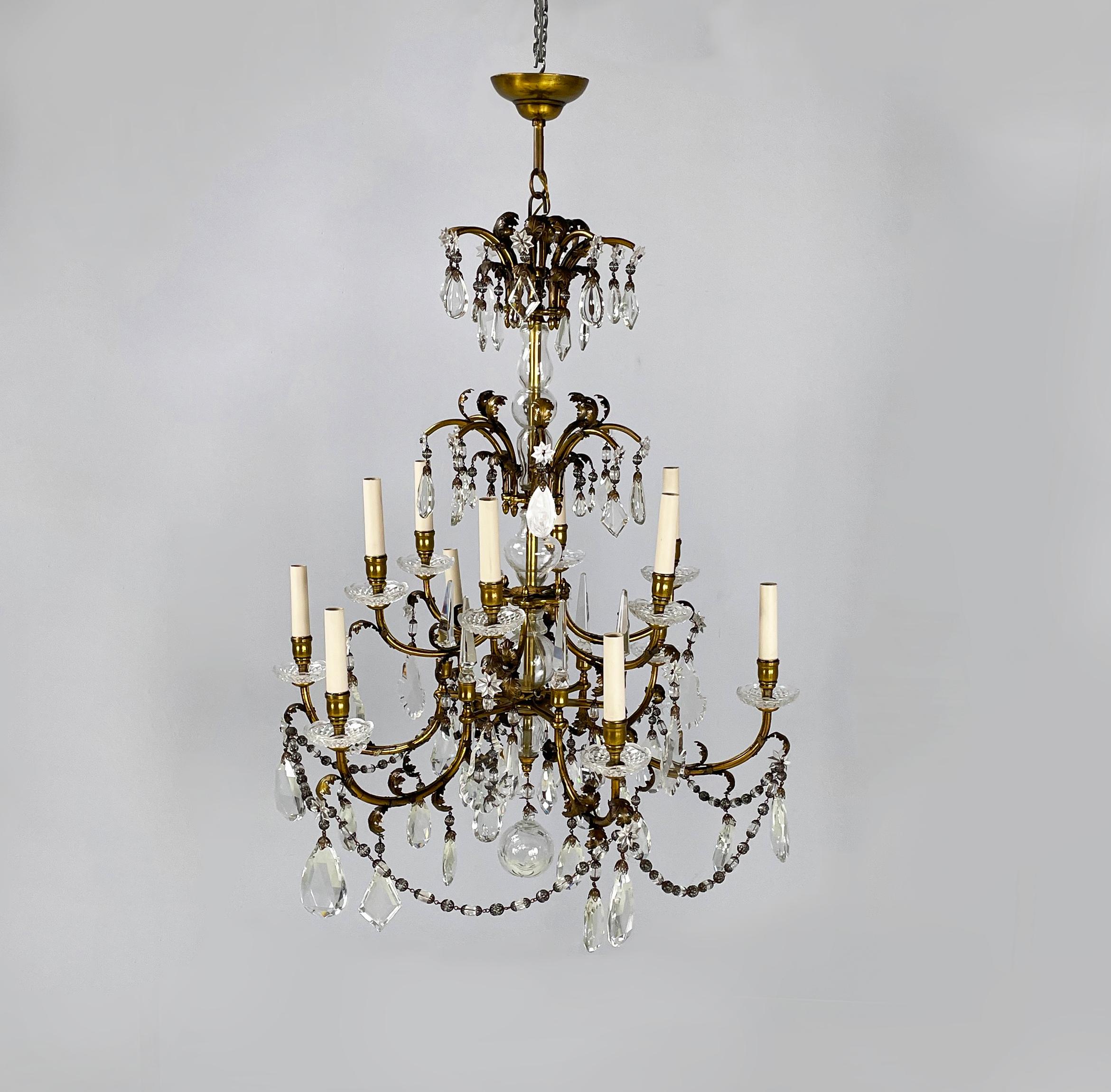Italian arte deco Glass drop chandelier with brass structure, 1900-1950s
Drop chandelier with round base. The brass structure is composed of a central brass tubular with 12 curved arms, divided into two levels of different heights, and shorter arms