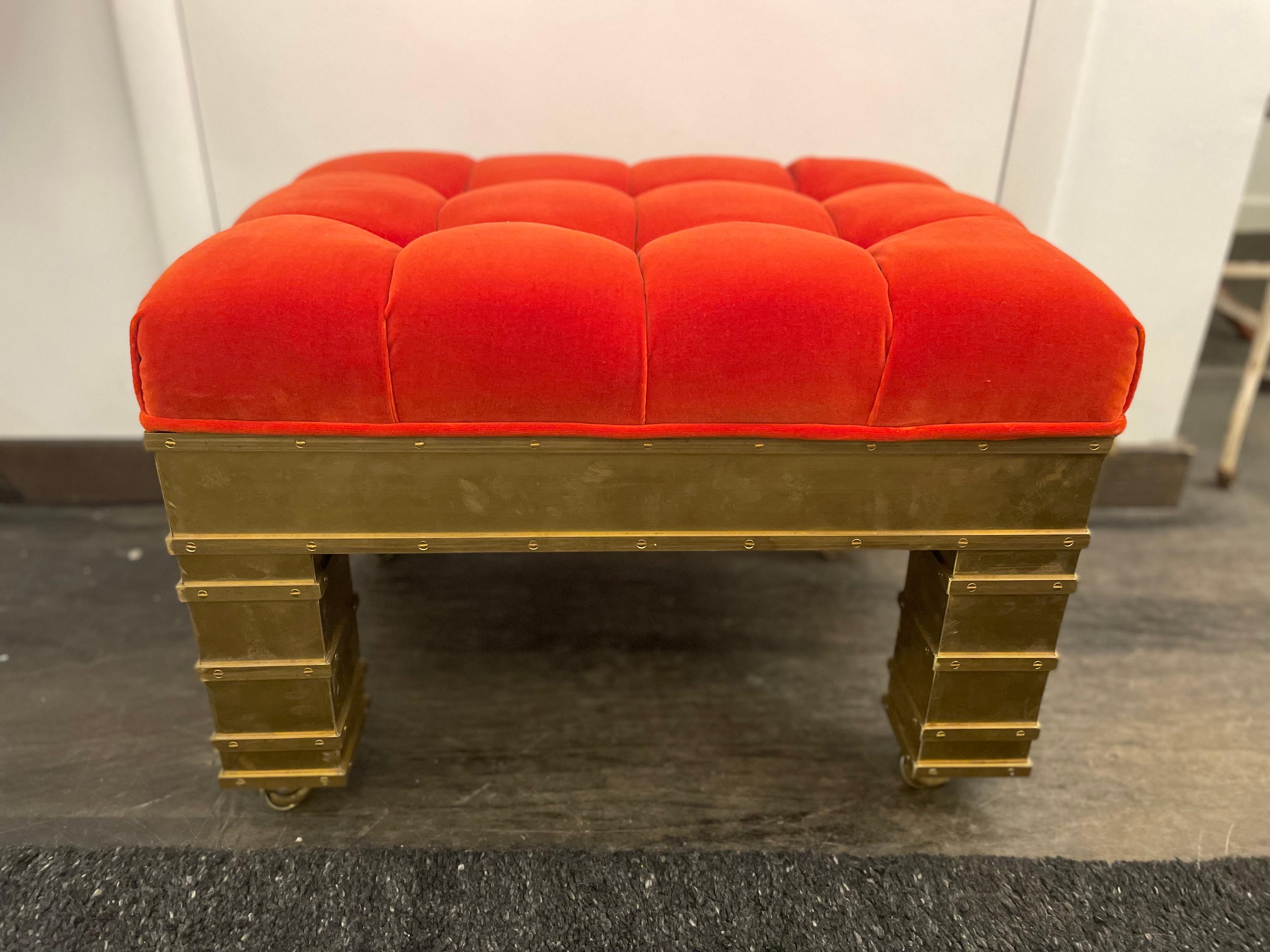 Persimmon colored silk velvet on a fully hand crafted brass clad on wood base + casters for easy movement. The European screws throughout this amazing bench/ ottoman is eye-catching. NOTE: upholstery of one bench is slightly taller than the other,