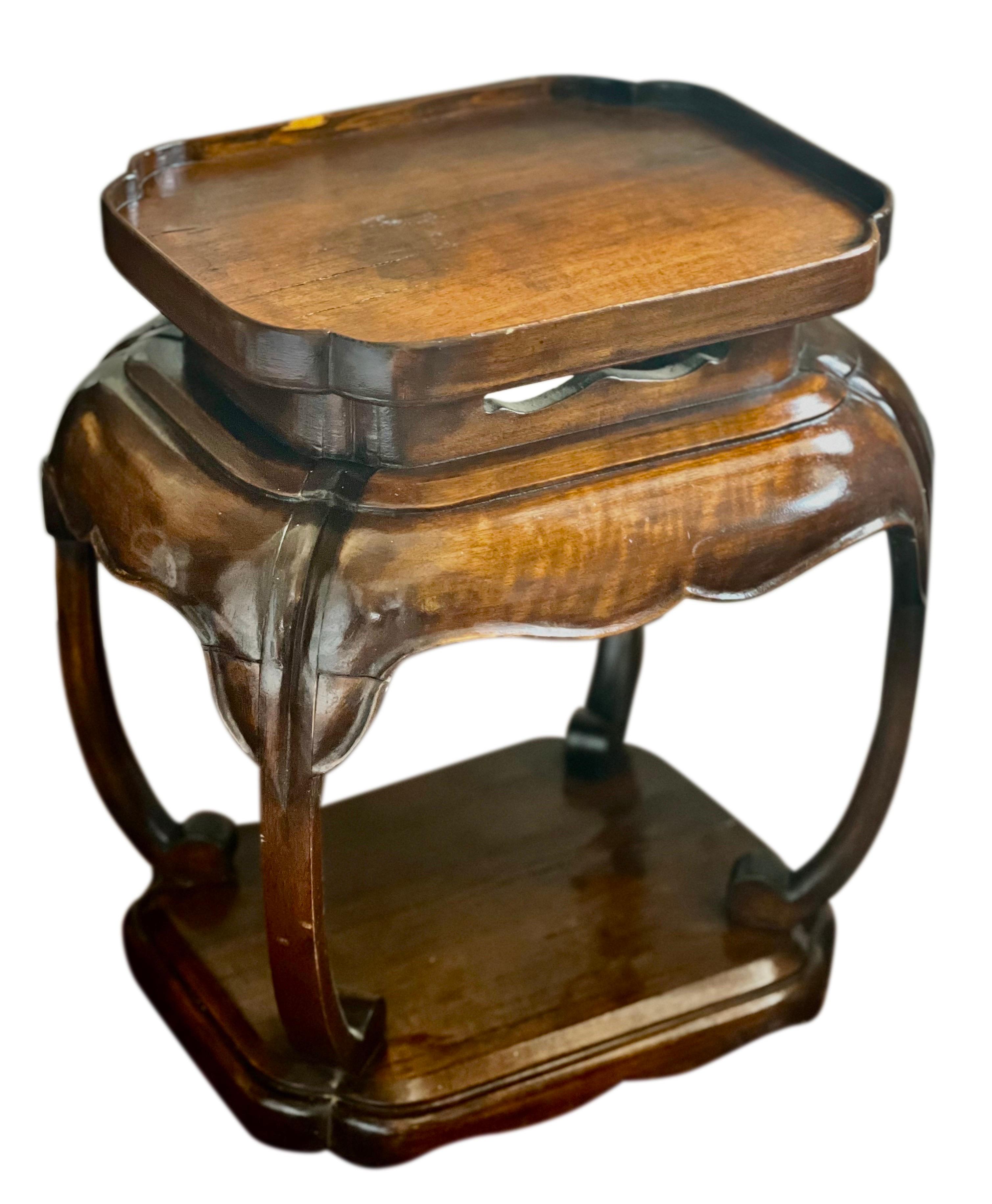A fabulous Italian, Asian inspired mahogany two-tier low side table, circa 1940's. 

This unique table boasts all the hallmarks of beautiful Italian craftsmanship with graceful curvature and carved details. It was crafted during a time in Italy when