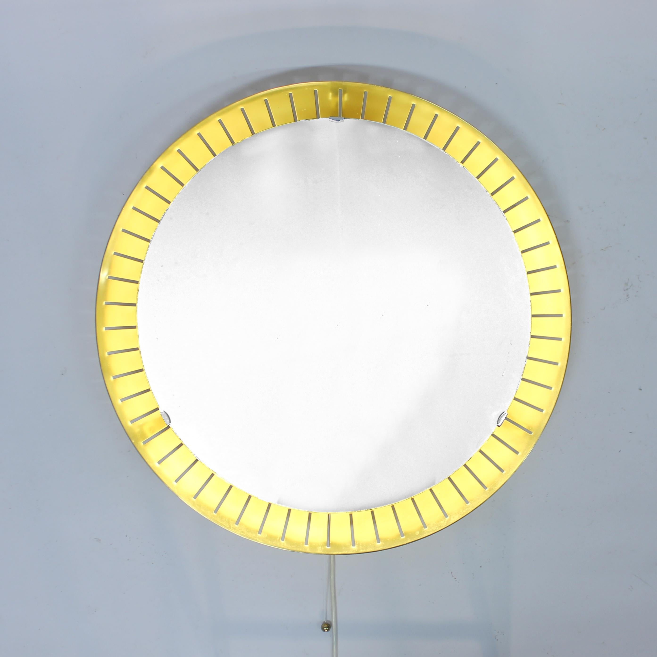 Fantastic Italian backlit round brass mirror, attributed to legendary Italian manufacturer Stilnovo and made in the mid-century, ca 1950s / 1960s. This model is sometimes also Hillebrand. Cool detail that the light switch is a brass ball on a rope