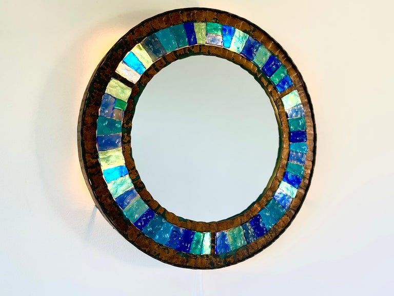 Rare backlit wall mirror manufactured by Longboard in Verona, Italy - 1970's.
Hammered glass and gilt gold leaf wrought iron in brutalist style.
Gorgeous original glass in various hues of turquoise. 
Newly rewired and lights up from behind. 
 