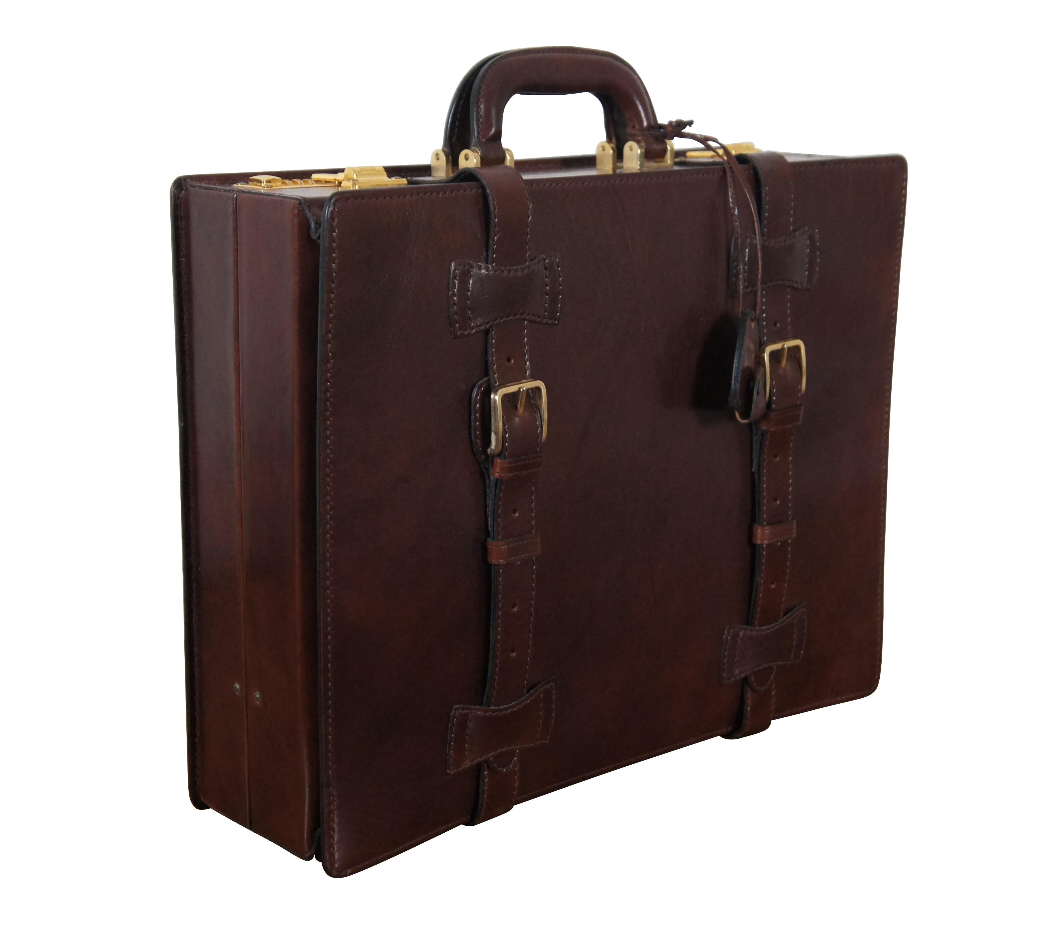 Vintage Bally dark brown leather brief case. Features brass feet, expandable front with two decorative buckle straps, and double latches with Presto combination locks (currently set to default combination 000). Interior features beige / off white