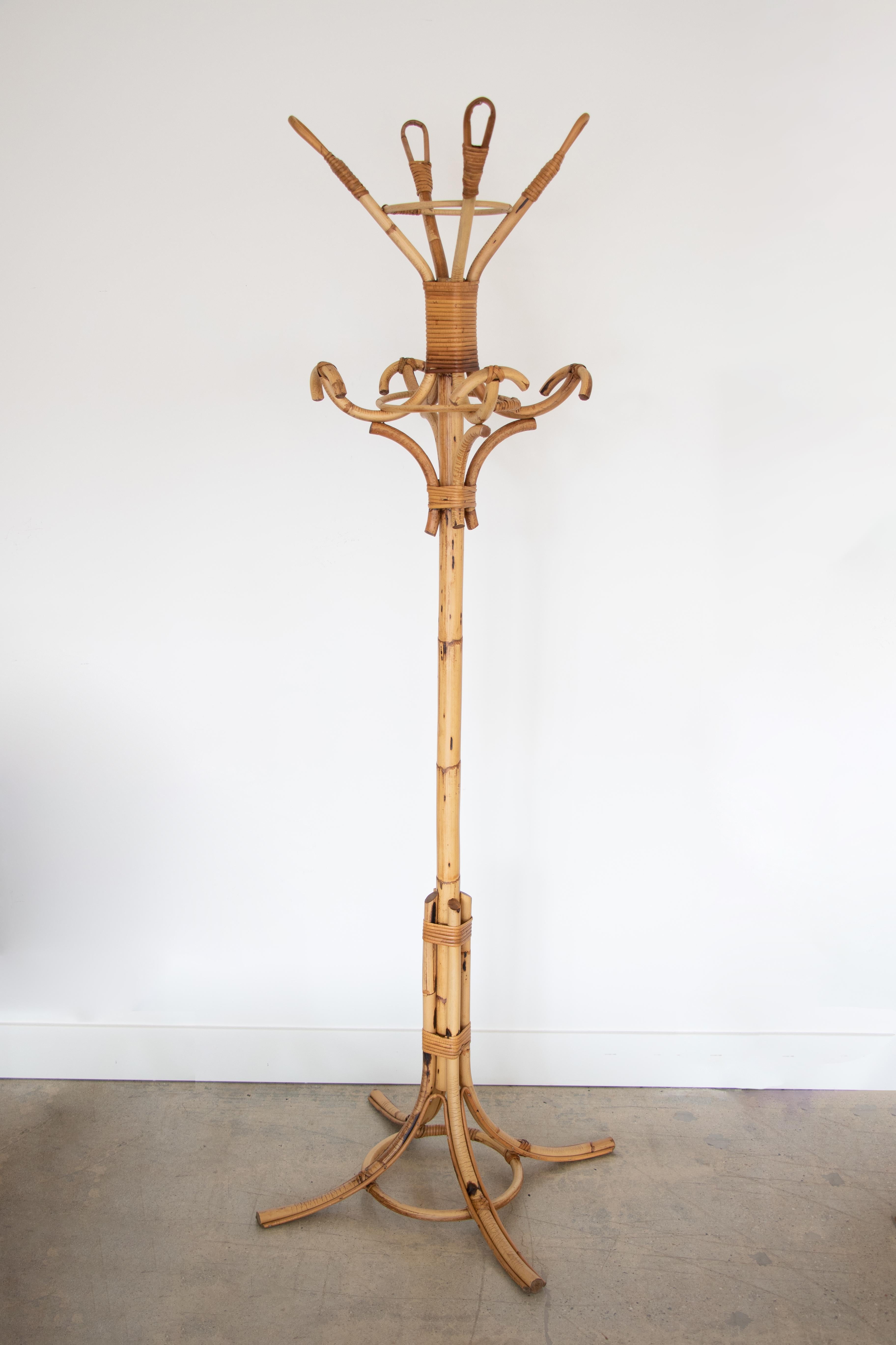 Vintage Italian rattan and bamboo standing coat rack attributed to Vittorio Bonacina. Beautiful hooks with 4 top loops and 4 arched rattan pieces to hang coats or hats. Great wrapped rattan detailing. 

Additional measurements: top diameter 17.5