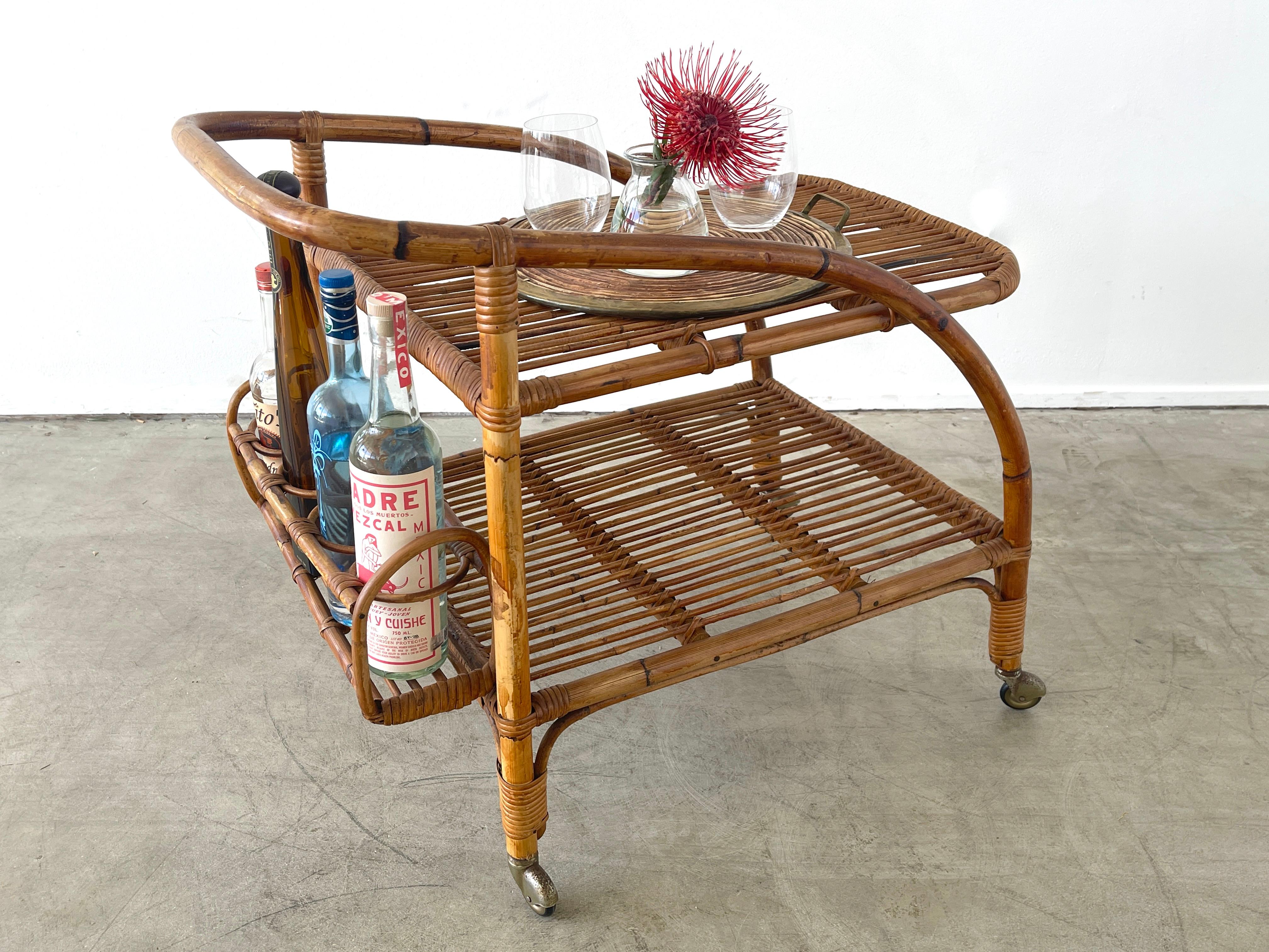 Charming Italian bamboo bar cart with all the right curves and function.
Sculptural shape with rack for liquor and 2 tiers for serving.
Original casters.