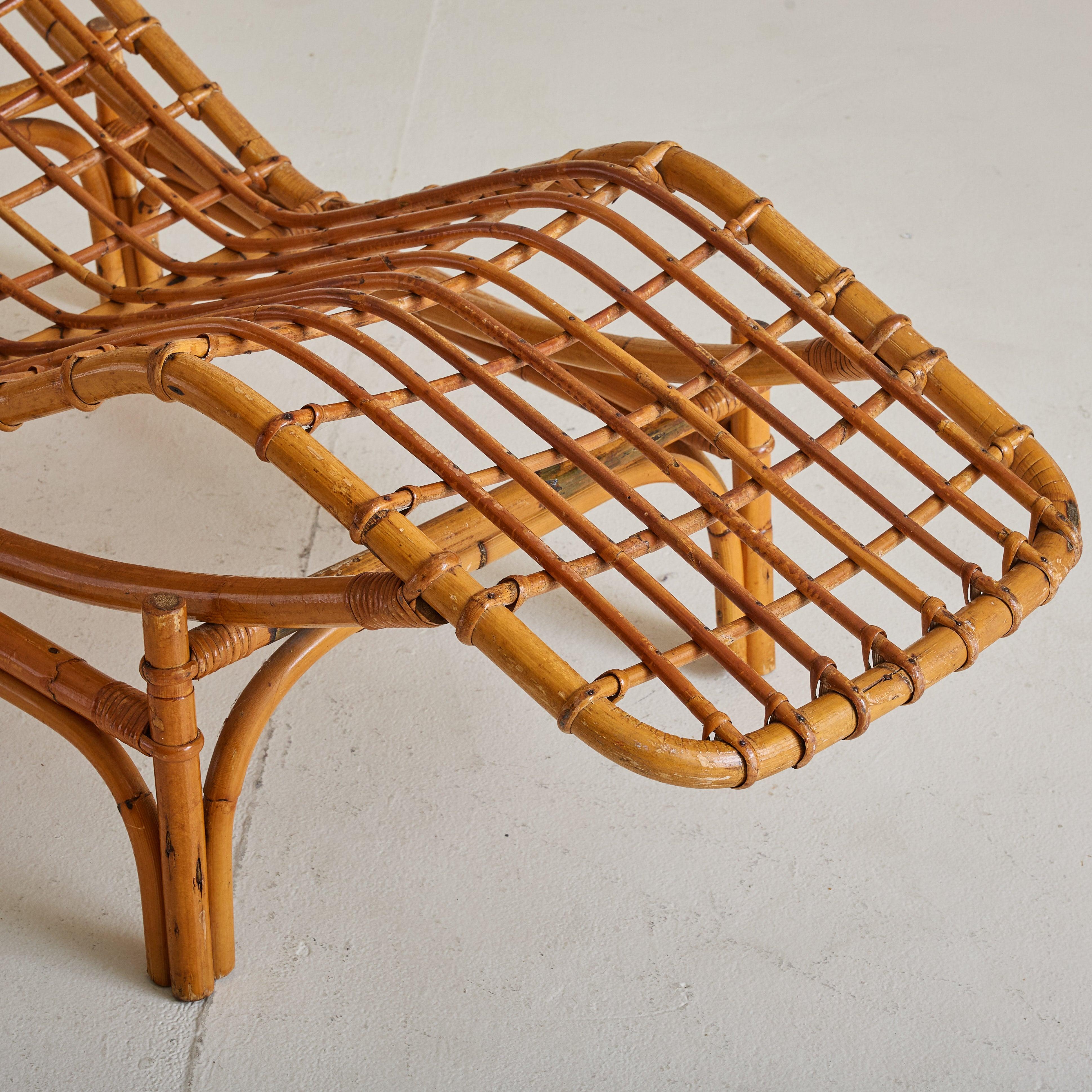 Ein skulpturaler italienischer Chaiselongue-Sessel aus den 1960er Jahren, der vollständig aus Bambus gefertigt ist. Sein geschwungener Rahmen umschließt den Körper mit müheloser Leichtigkeit. Das Design - eine zweiteilige Konstruktion - ermöglicht