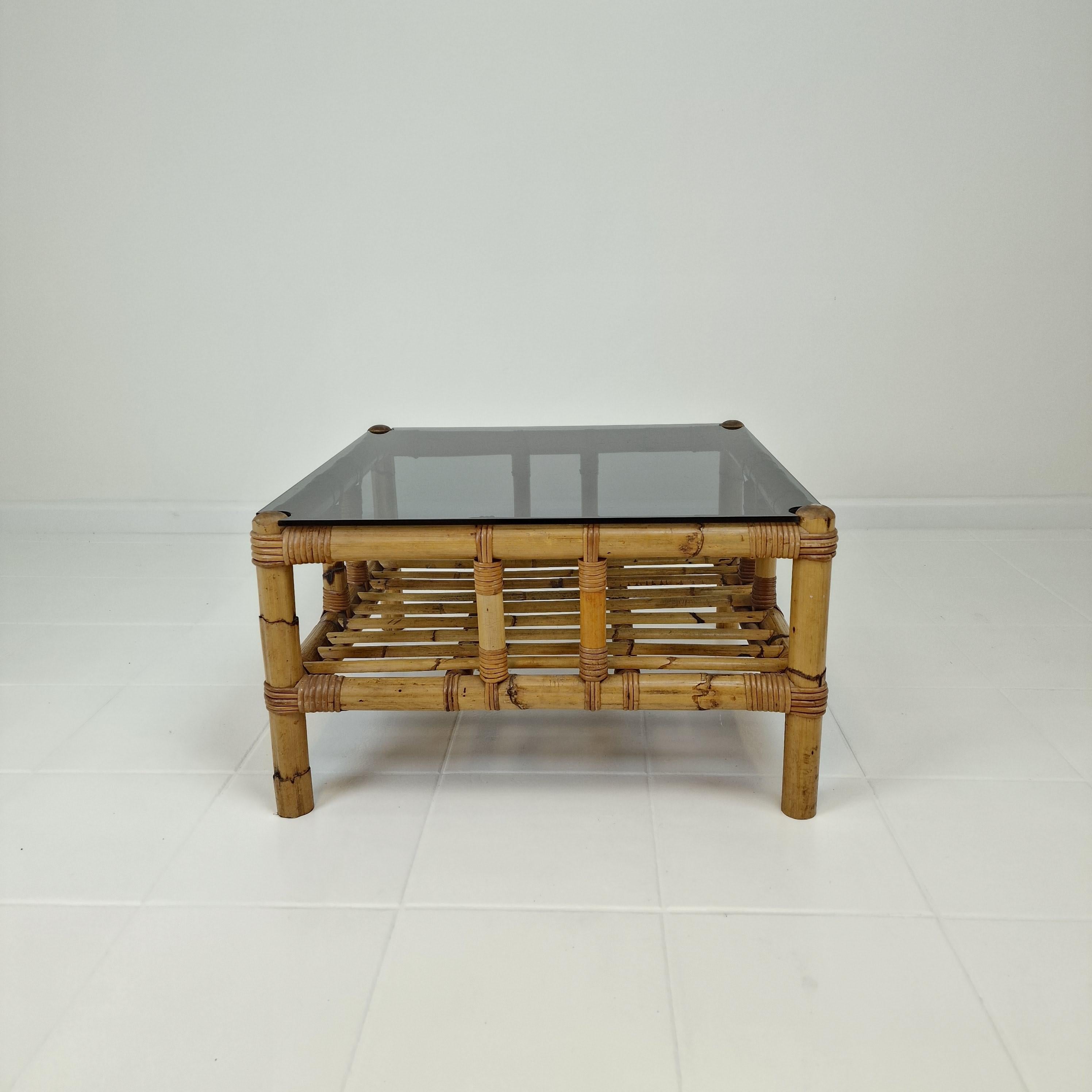 Jolie table basse ou table d'appoint rectangulaire, fabriquée en Italie dans les années 70. 
Cette très belle table est faite de bambou et de verre.
La plaque est en verre fumé.

Il présente les traces normales d'utilisation et un petit éclat sur un