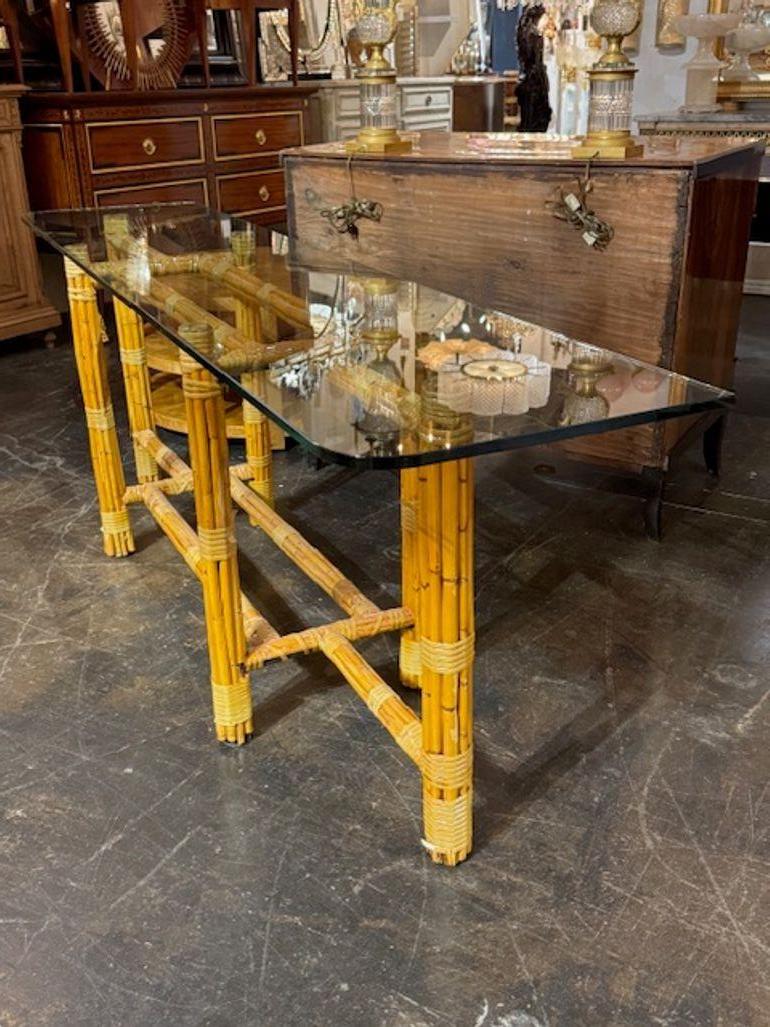 The Italian Bamboo Console with Glass Top is a stylish and modern furniture piece perfect for adding a touch of textural interest to any room. The glass top combined with the natural beauty of bamboo offers a unique and mid century modern  design