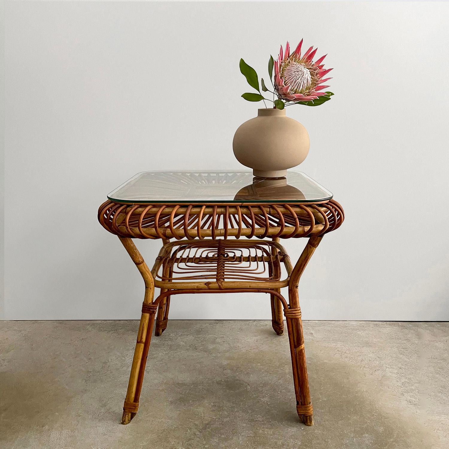 Italian bamboo & rattan table
Italy, 1960s 
Magnificent handcrafted artisanal piece with great attention to detail
Beautifully sculpted rattan reeds radiating from the center axis encompass the solid bamboo frame
New glass has been added to increase