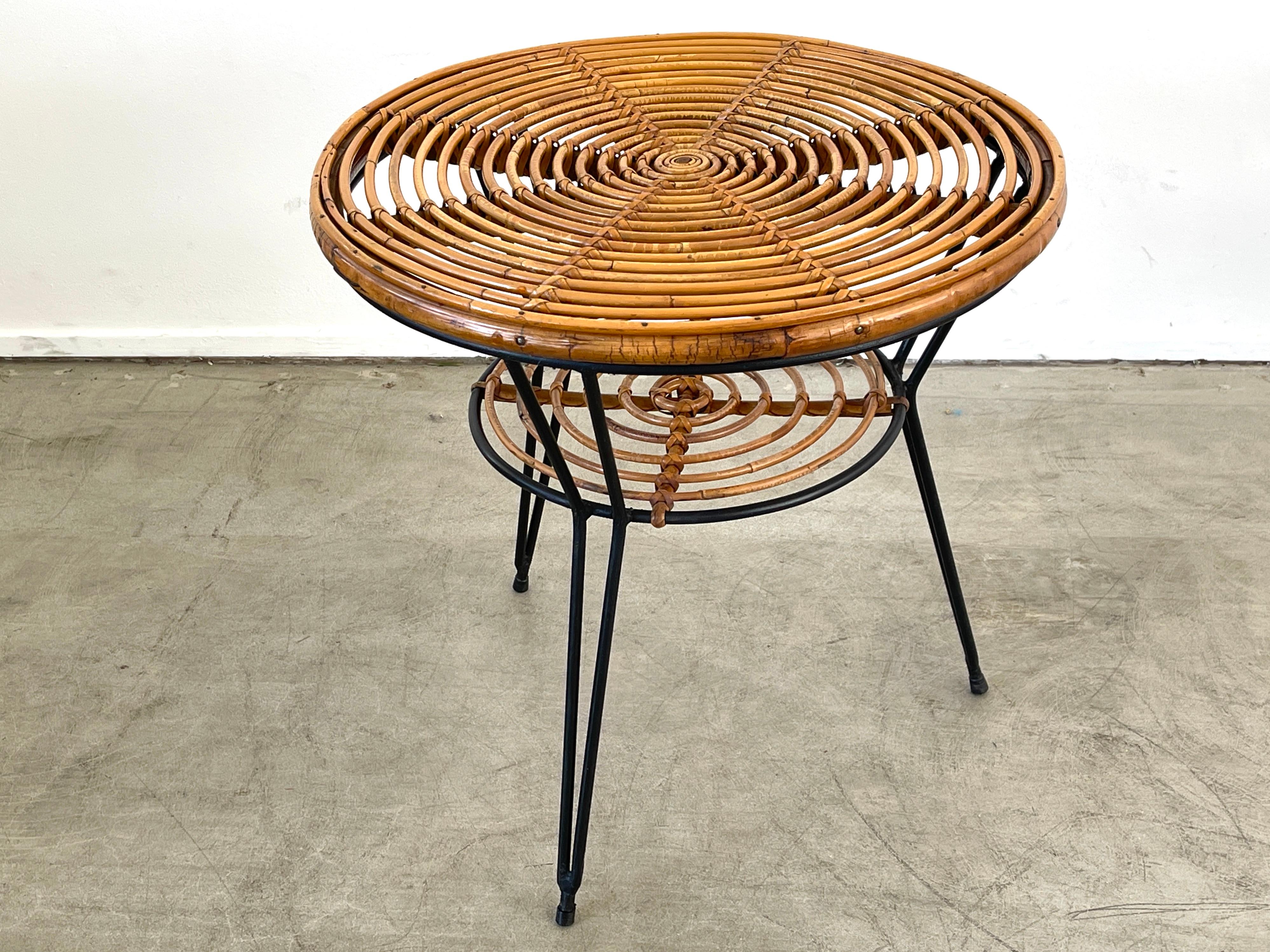 Bamboo and rattan coffee table with two shelves and iron hairpin legs.
1950's Italy in the style of Tito Agnoli.