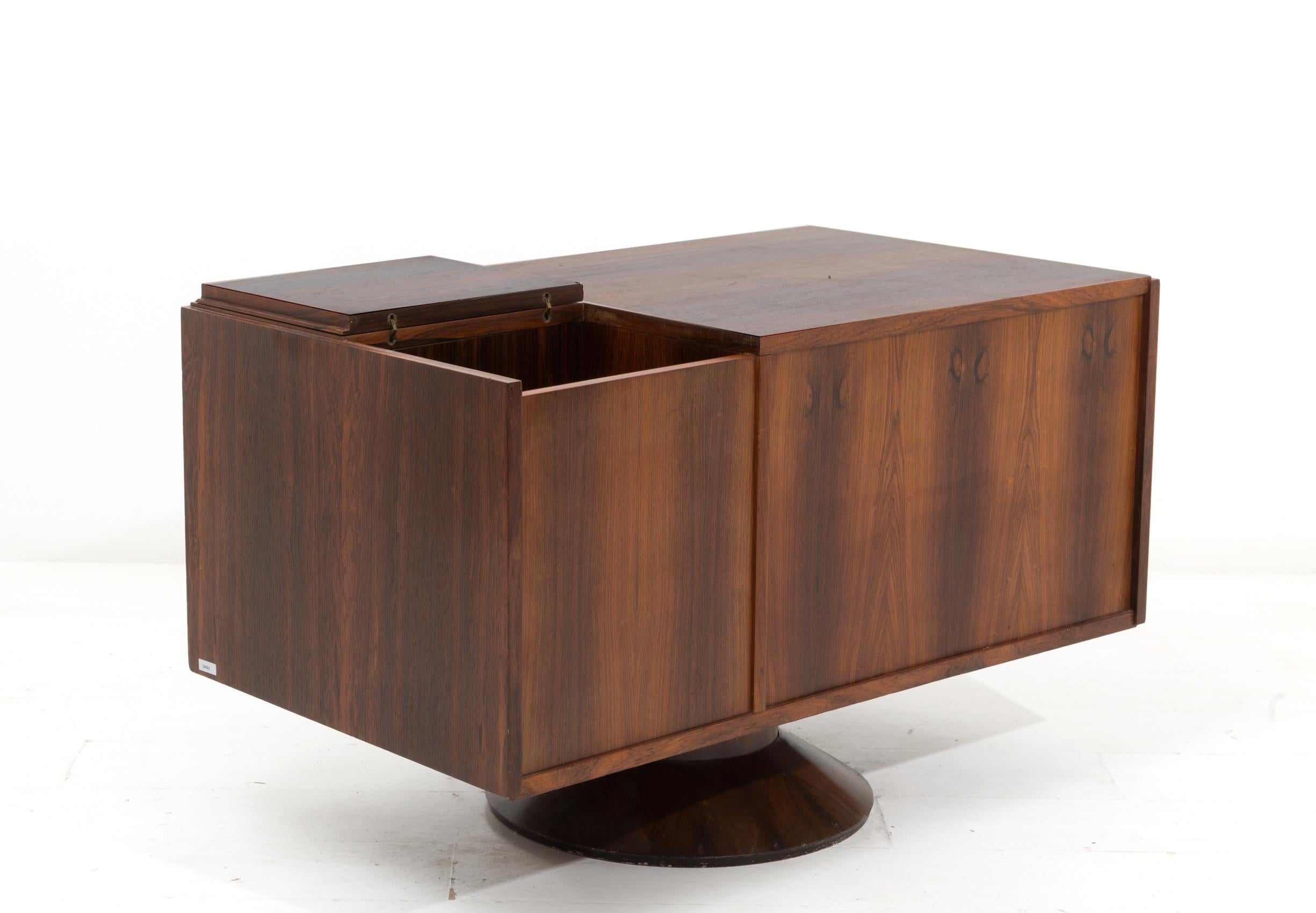 Eccentric swivel bar cabinet from the Italian centre of the 1950s, designed by Gianfranco Frattini for Bernini. The cabinet is made of precious woods. The peculiarity of the cabinet is its swivel pedestal that with its mechanism allows the cabinet