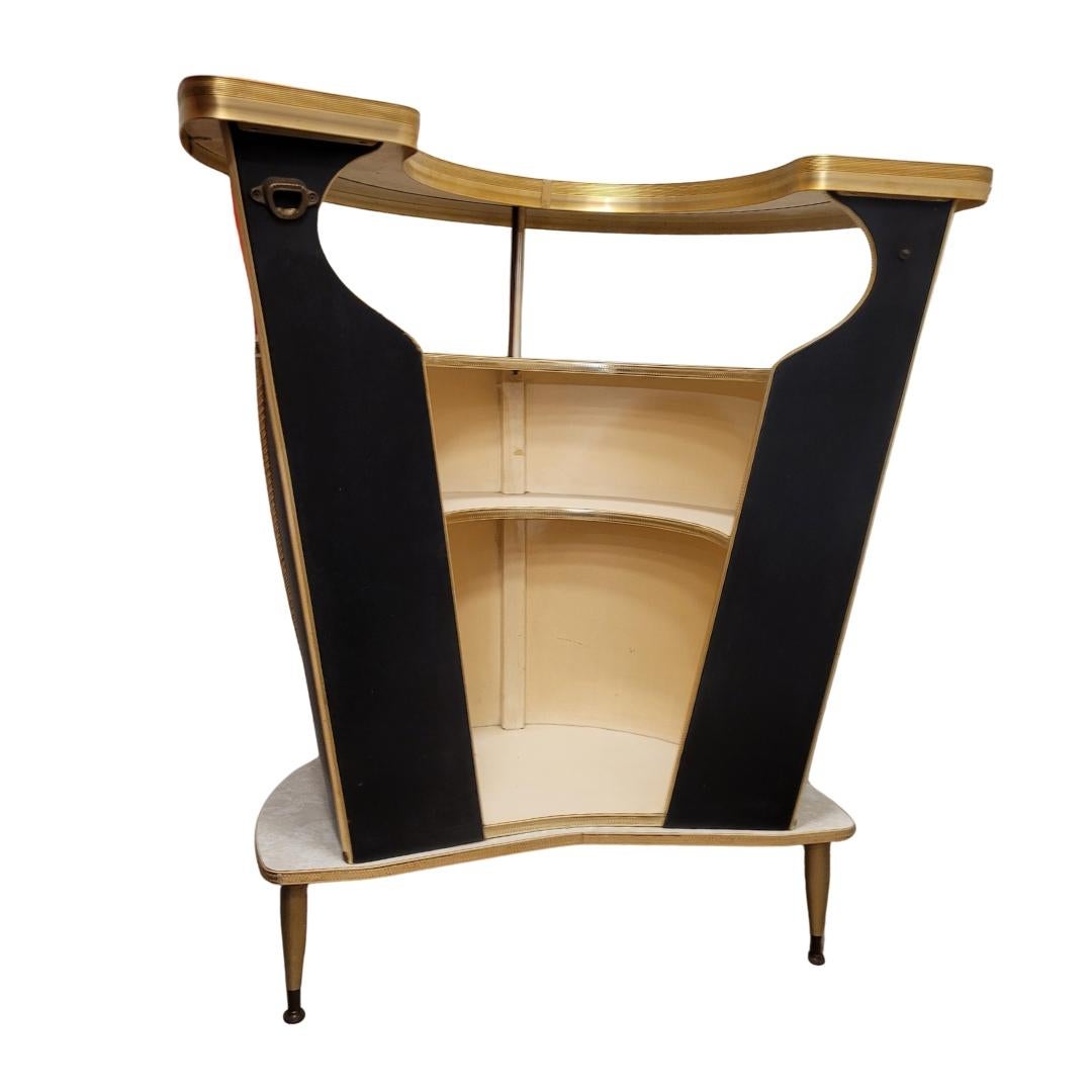 Amazing and refined Italian designer bar cabinet, 1950s / 60s. Following the style of Umberto Mascagni, an Italian designer who worked for Harrods in the 1950s, this small curved bar cabinet is ideal for any home. It can store many glasses, bottles,