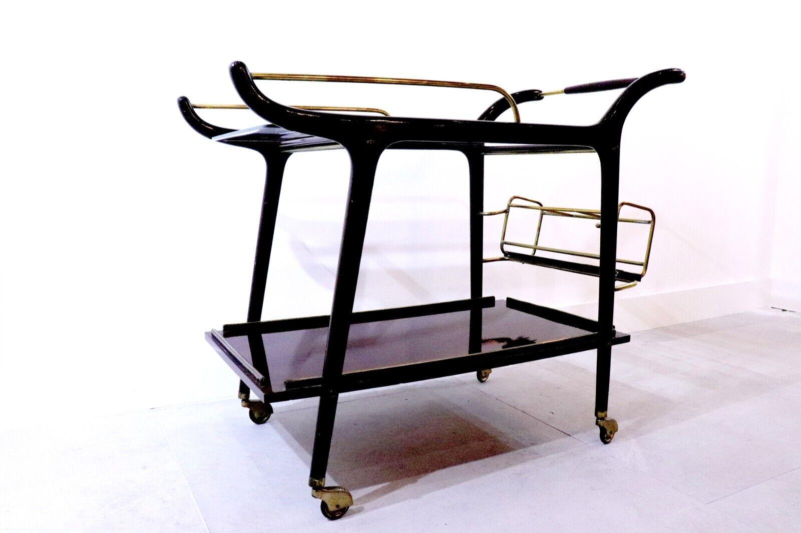 Italian 1950s bar cart, set on wheels with a glass top and stained beechwood base; Plenty of room for drinks, glasses and assembly with a secure holder for bottles at the rear.
 