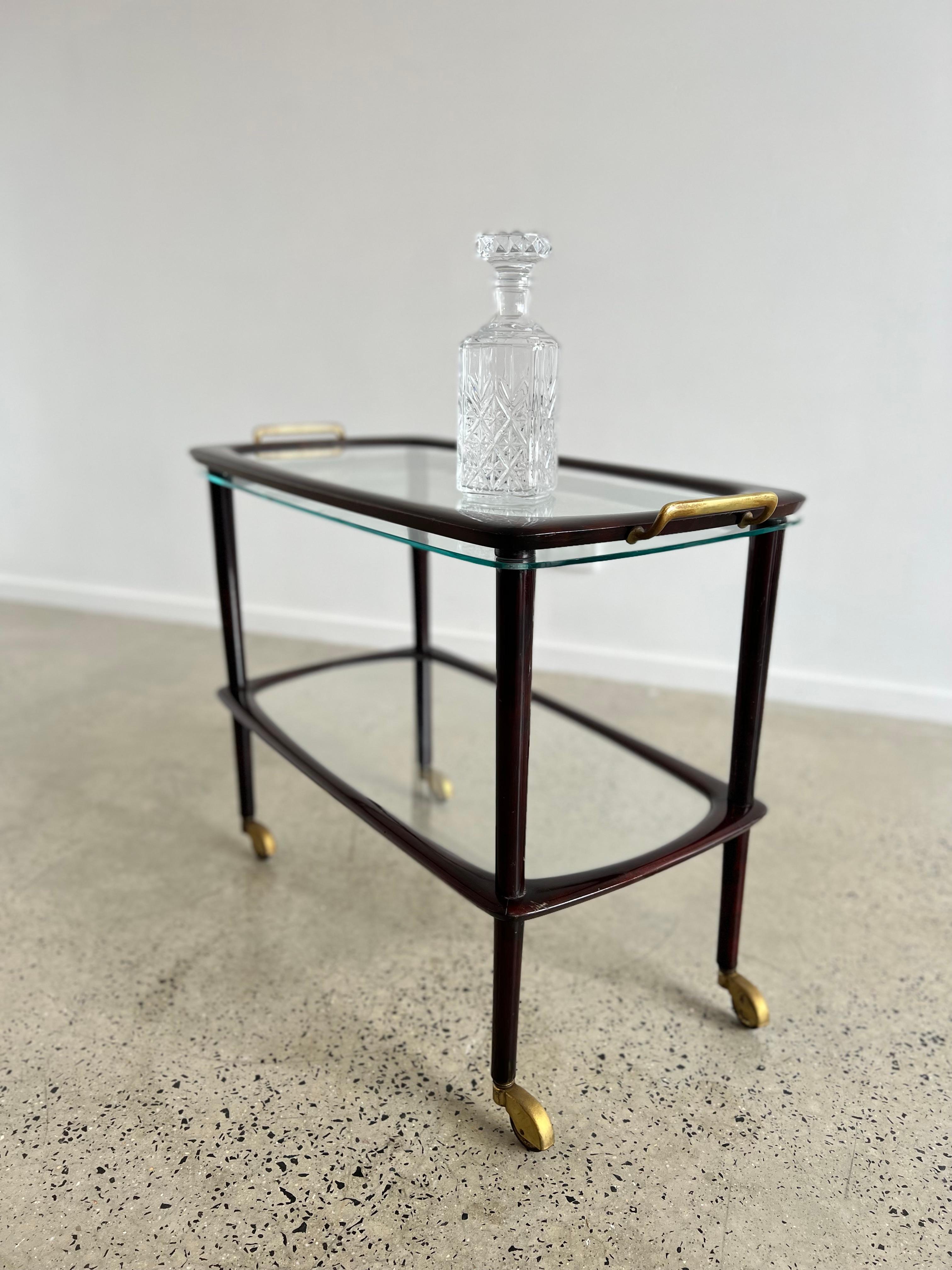 Wonderful Italian wood trolley with glass and brass finishes. It has a removable serving tray with brass and chrome finishes.
This 1950s production is attributed to Cesare Lacca, has wonderful rounded lines and materials plus amazing brass