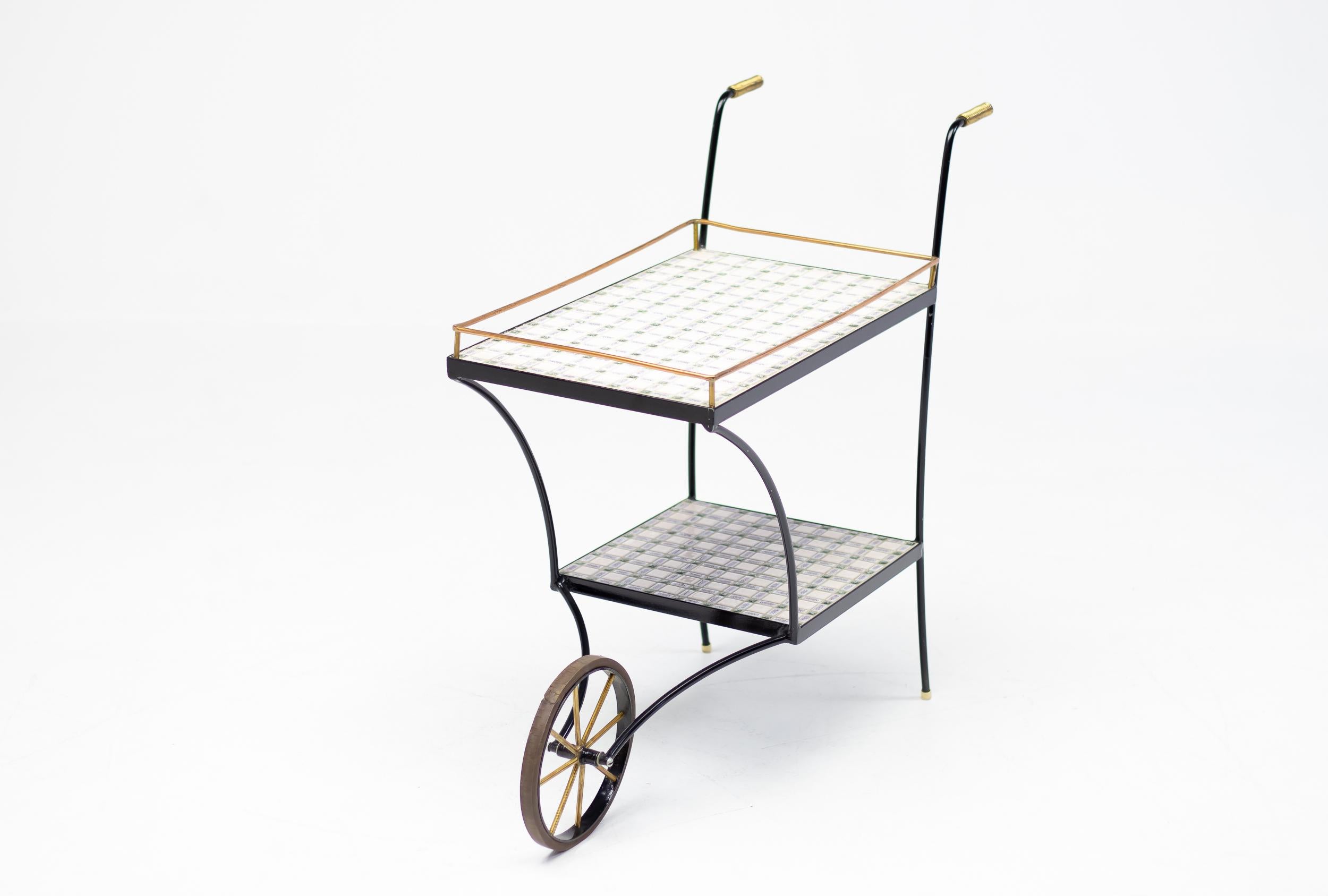 Wonderful Minimalist mid-20th century modern bar cart, made circa 1960 in Italy.
Miniature tiles in different sizes form a beautiful pattern.
Very stable when standing but light and easy to maneuver.
In excellent vintage condition.
Unique piece!