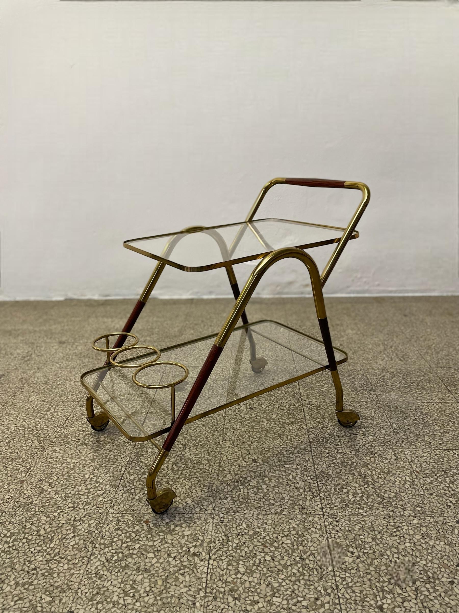 This classy Italian bar cart by Cesare Lacca from the 1950s is a true embodiment of Mid-Century Modern elegance. Crafted from high-quality brass and rich cherry wood, this piece exudes a warm, inviting glow that is perfectly complemented by its