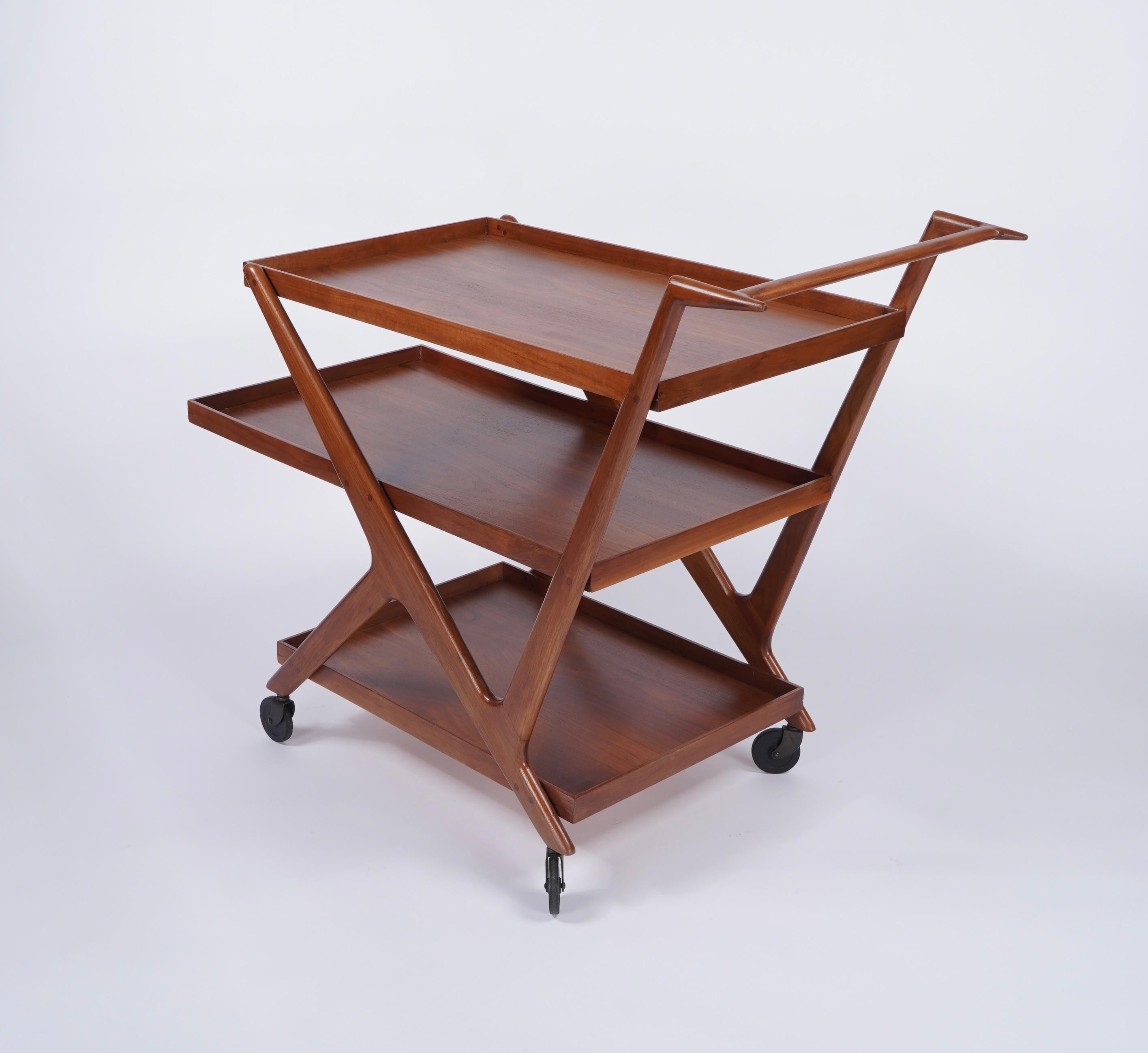 Sculptural bar / tea cart in walnut with 3 levels of shelves with the center being the largest and all with figurative graining. It reminds me of a vintage Ferrari or a jet getting ready to take flight, the appearance of moving while standing still.
