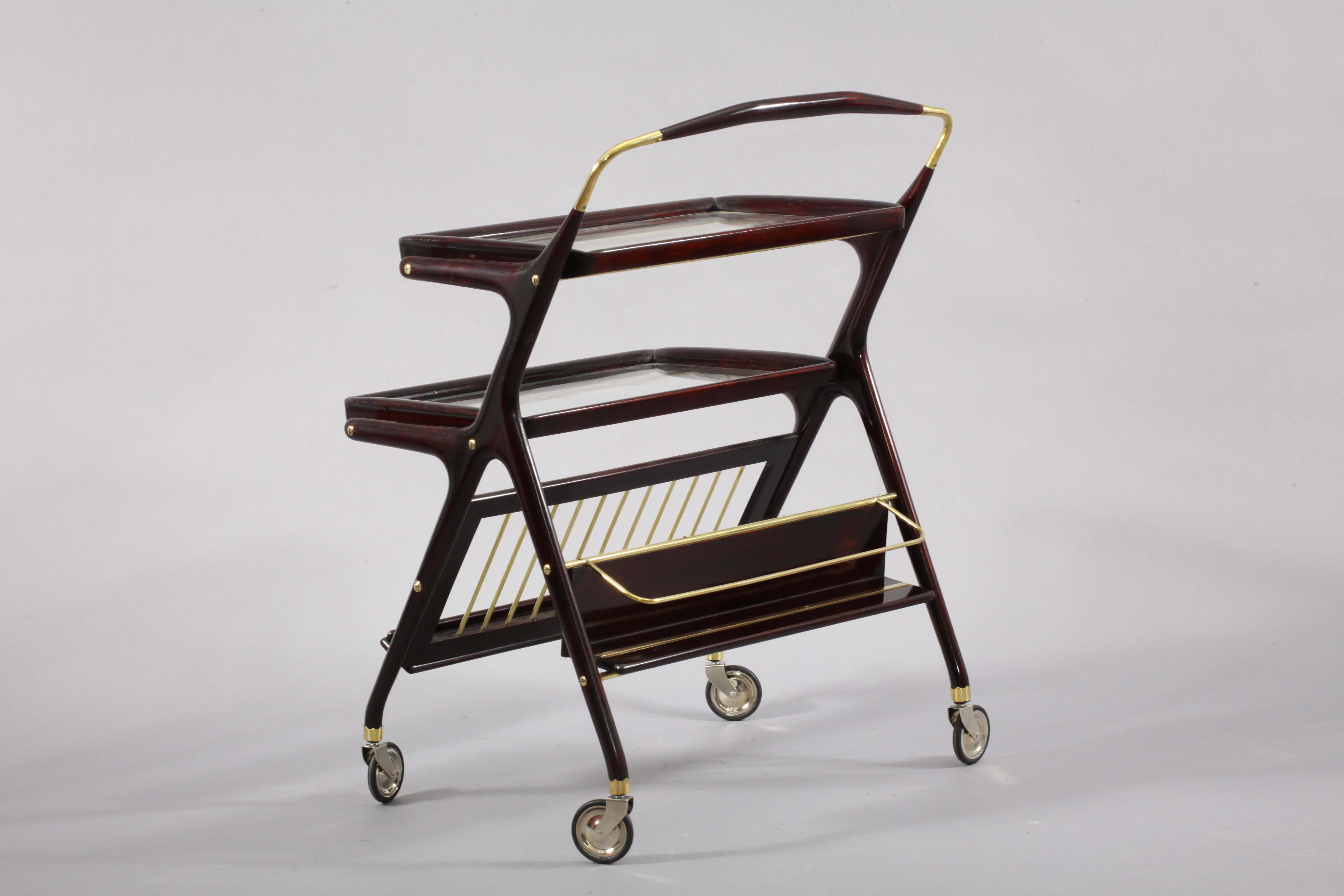 Bar cart attributed to Cesare Lacca with a smooth wooden frame and two serving trays with glass bottoms.
Bottom front rack for magazines, rear shelf for bottles.
 