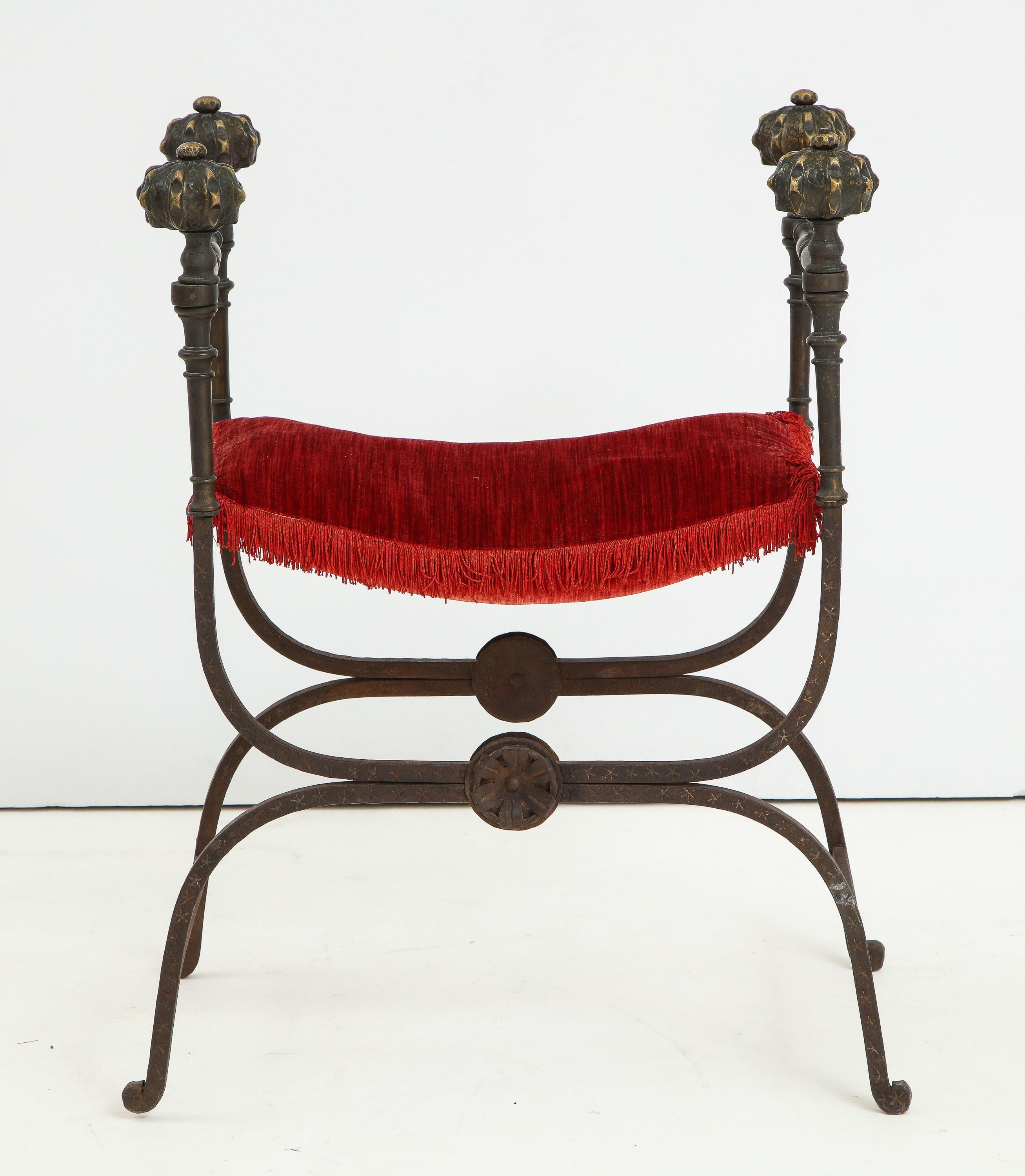 Italian Baroque iron folding seat (Faldistorio) with pomegranate bronze finials and turned bronze shafts, the 