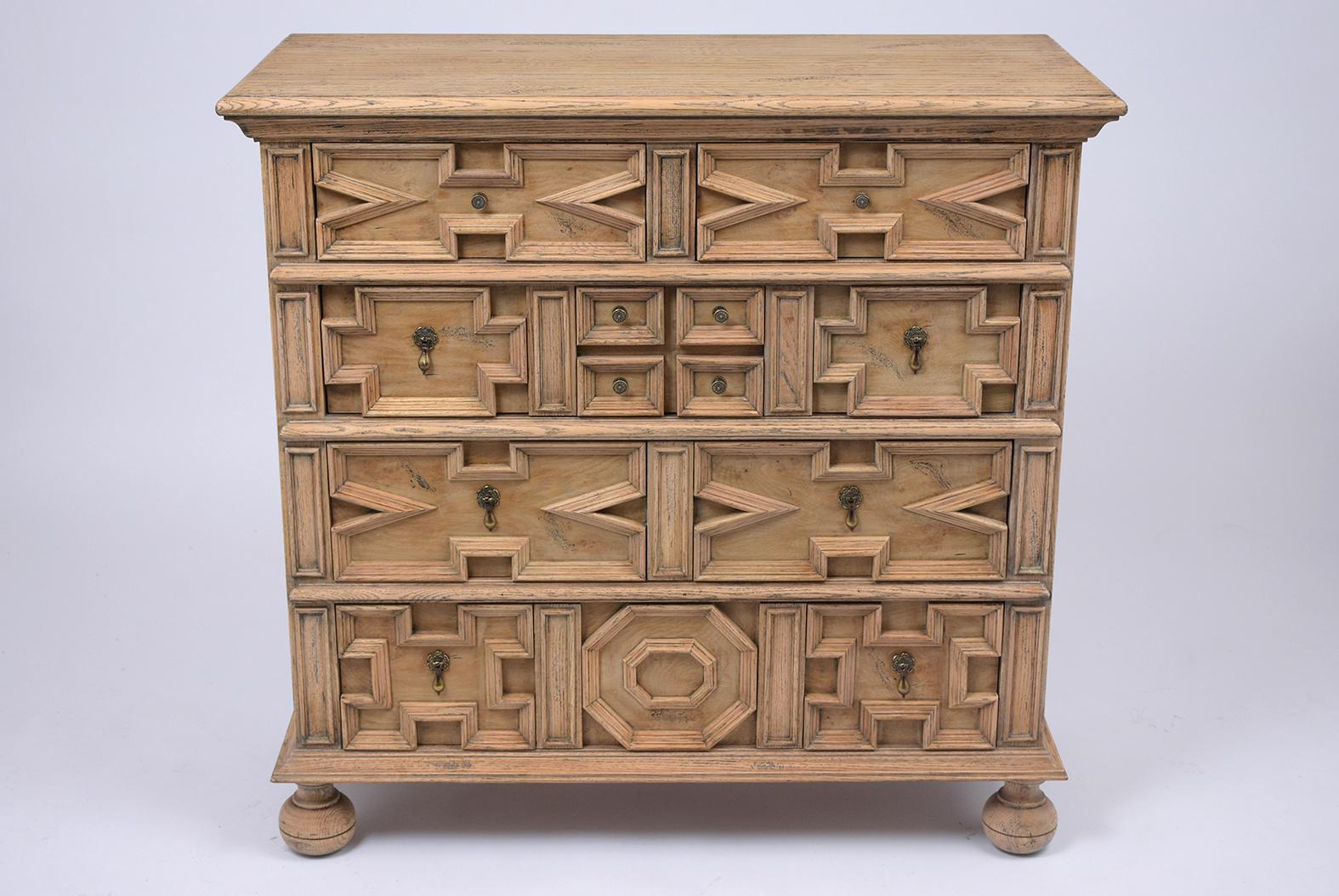 This vintage Italian Baroque style dresser has been restored is made out of oak wood with newly bleached finish. This piece features a wooden top, four drawers with symmetric design, molded paneling, and comes with brass knobs and handles. This
