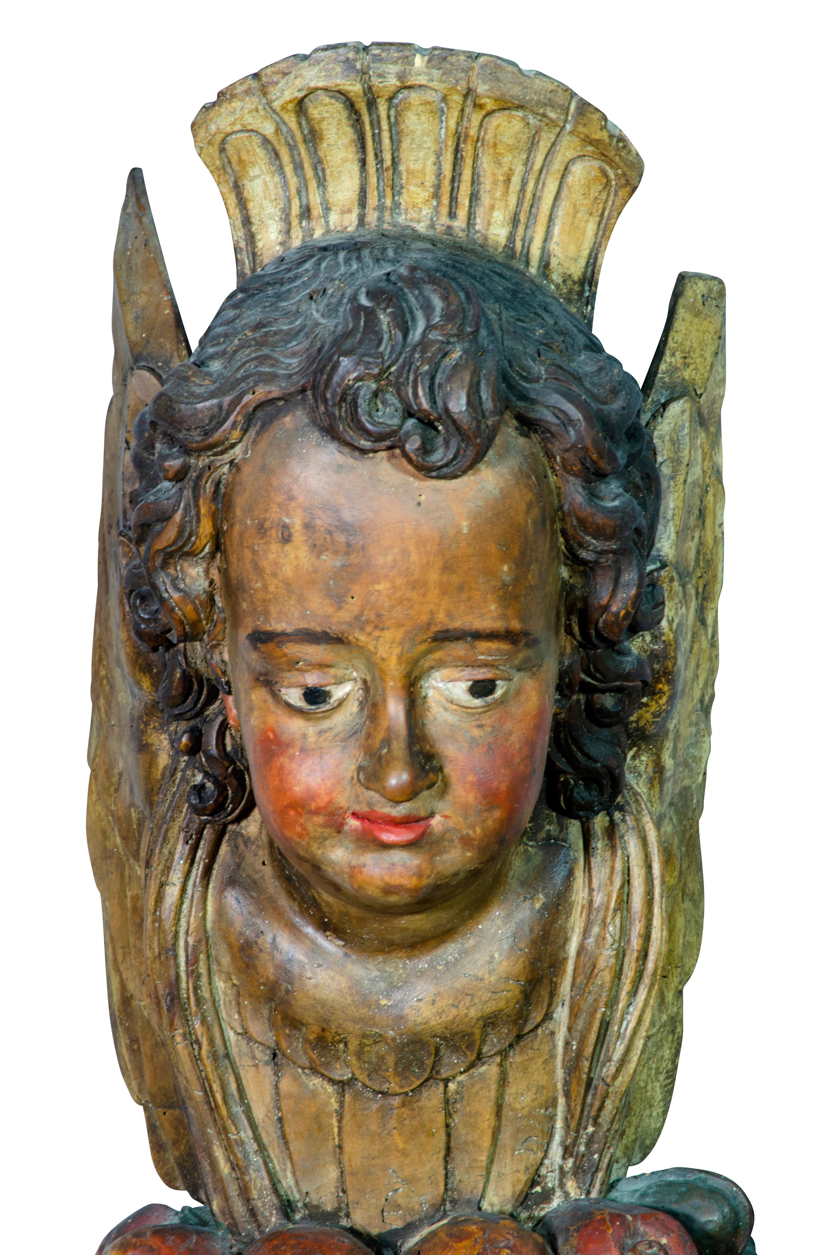 Carved and painted wood figure of a cherubic face and cluster of fruit.