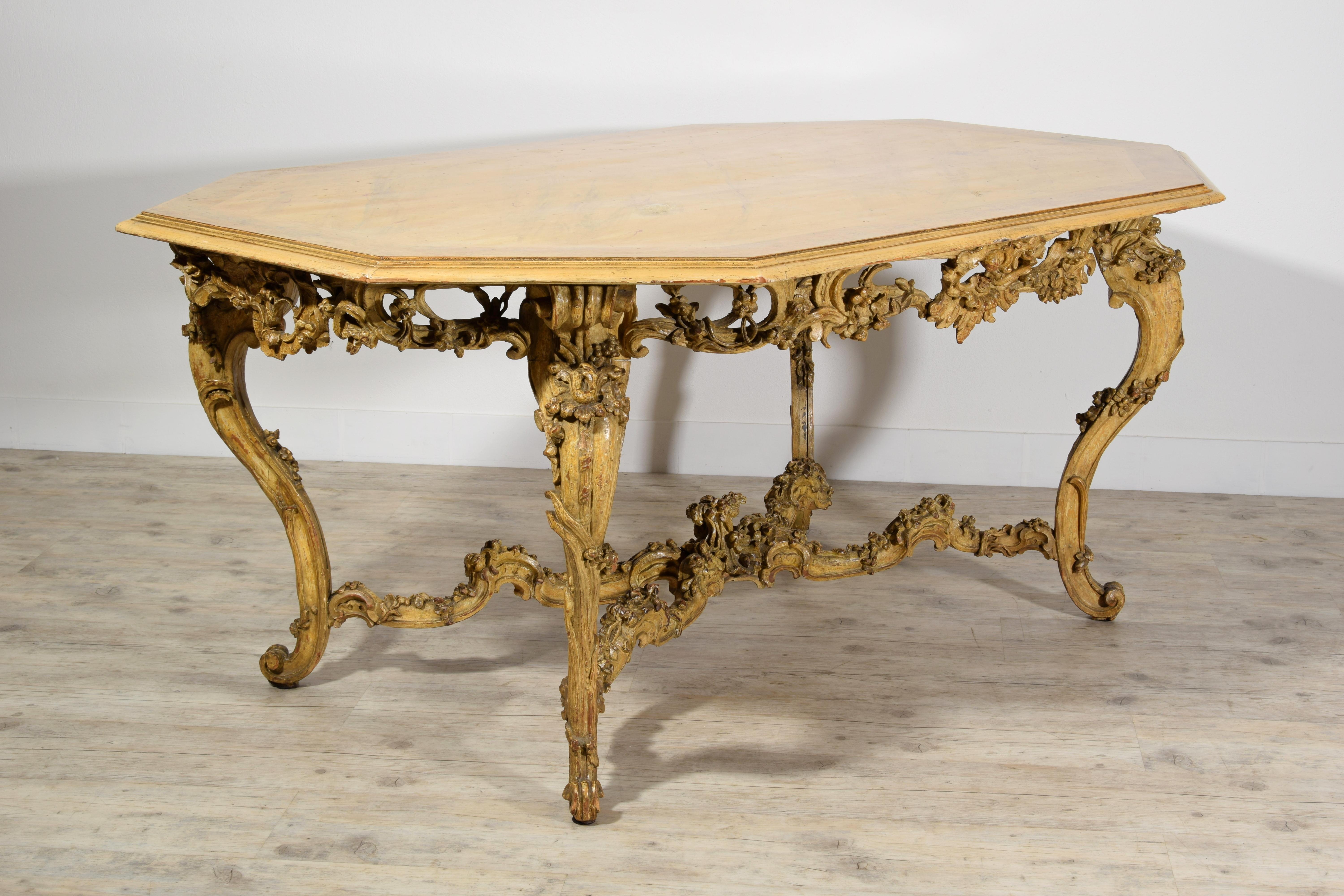 Italian Baroque carved gilt and lacquered wood center table, 18th century 
This particular center table is made of golden and lacquered in ochre finely carved wood with rich floral decorations. The band below the top has a perforated ornament with