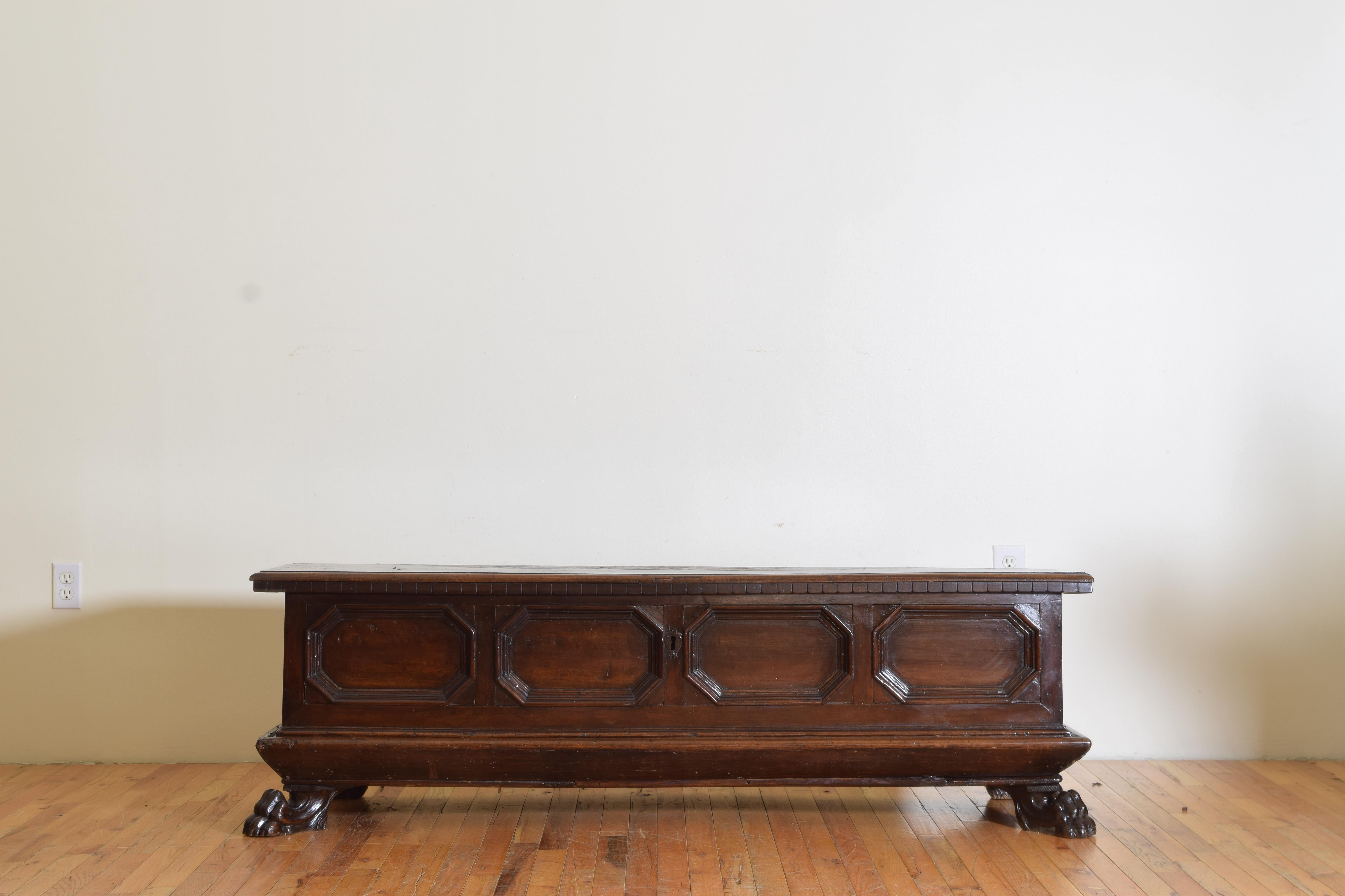 Having a rectangular top with molded edges and a gadroon carved front which is hinged at the rear and opens to reveal a large storage well, the front with molded horizontal octagonal panels, the sides with molded edges, having a plinth form base