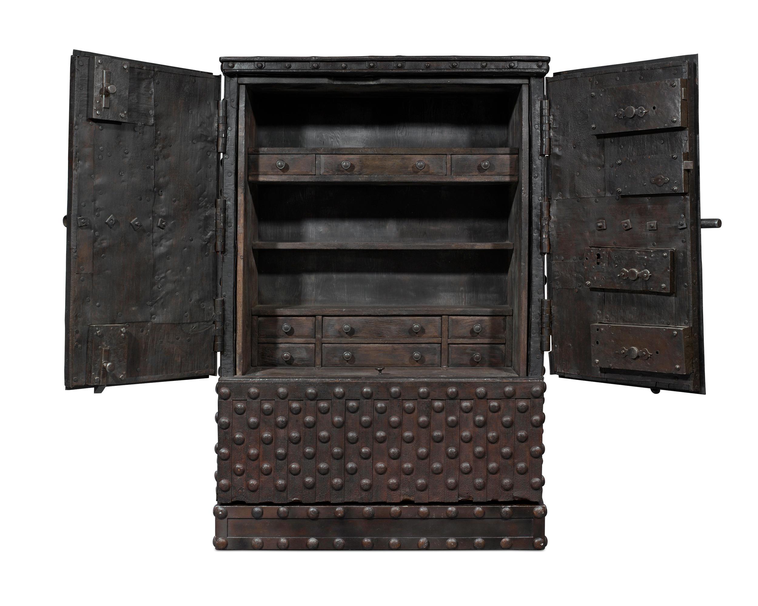 This rare Italian Baroque double-door safe is crafted of reinforced wrought iron and is designed to be virtually indestructible. Intended to secure one's most precious valuables, the fascinating structure is enveloped in thick iron strapwork that