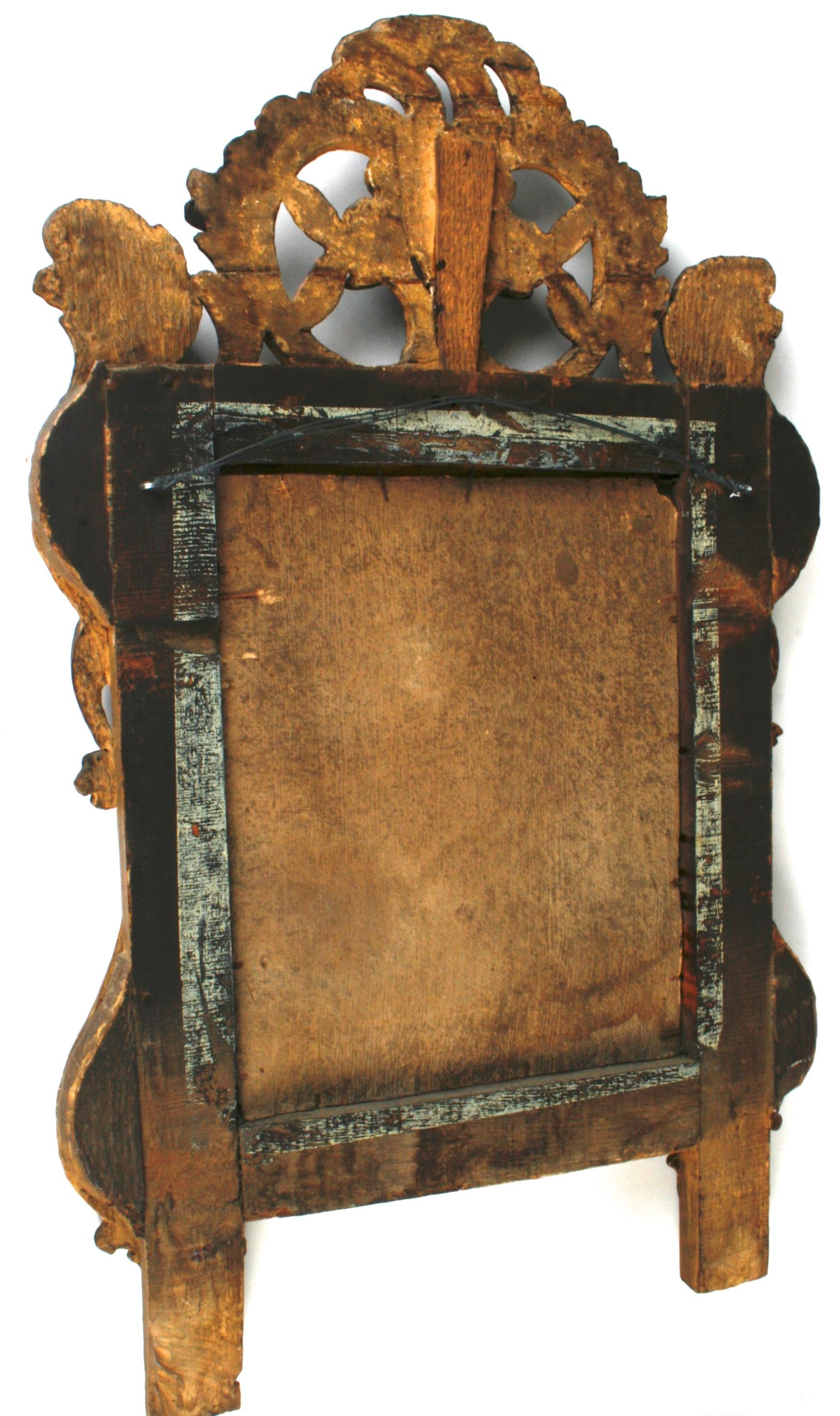 An Italian Baroque giltwood and painted mirror, c1750. This beautifully framed mirror has its original mirror plate and is crowned by a central cartouche of patinated flowers. Centred at the base: A carved and gilt shell introduces an intertwining