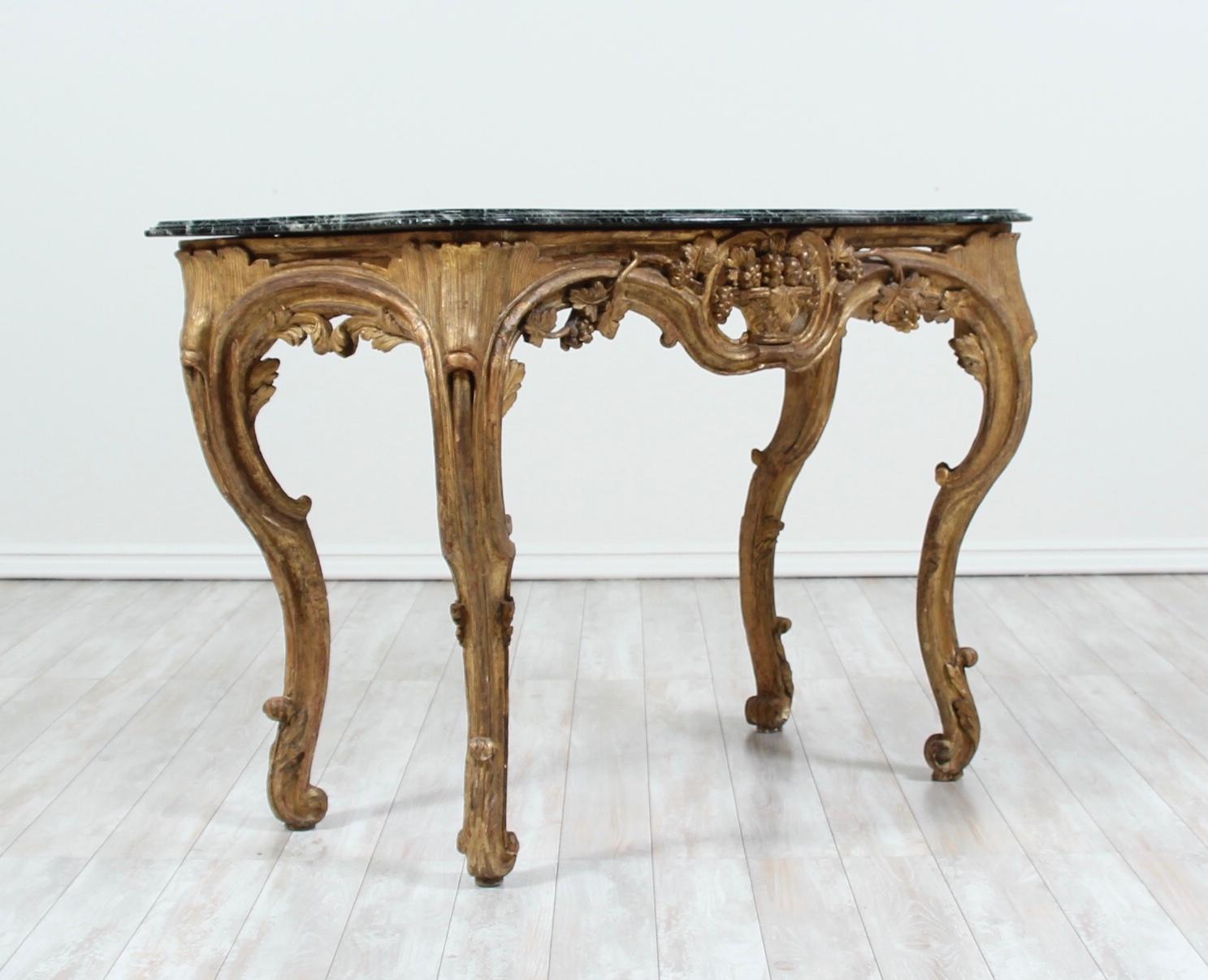 Beautiful, antique 19th century Italian giltwood console with a deep green marble top in the Baroque style. The console features a carved grapevine motif with a basket of fruit at the center of the frieze and cabriole legs. A wonderful addition to