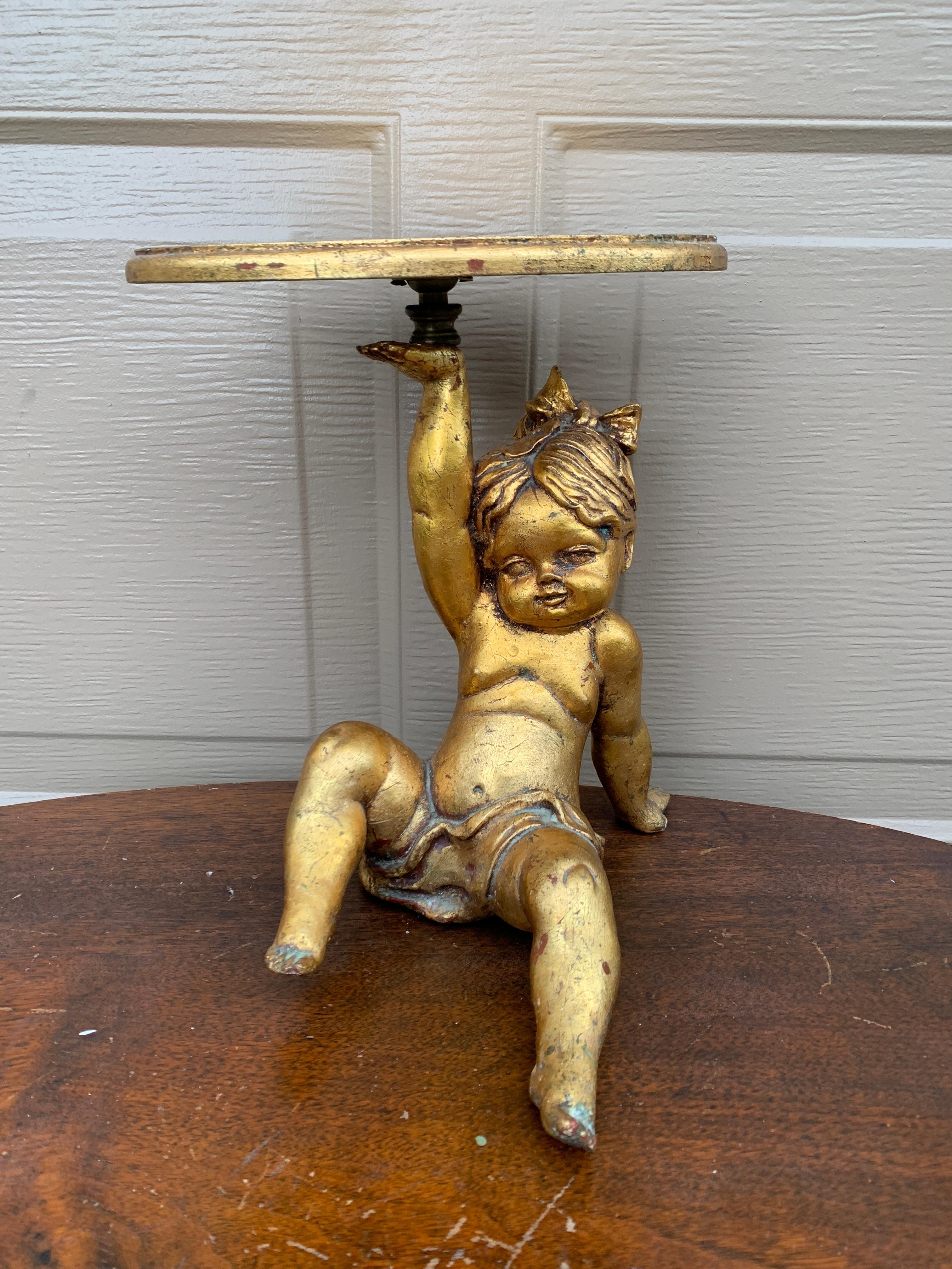 A gorgeous Neoclassical or Baroque style gilt wood shelf sconce being supported by a putto or cherub

Italy, Circa Mid-20th Century

Measures: 10