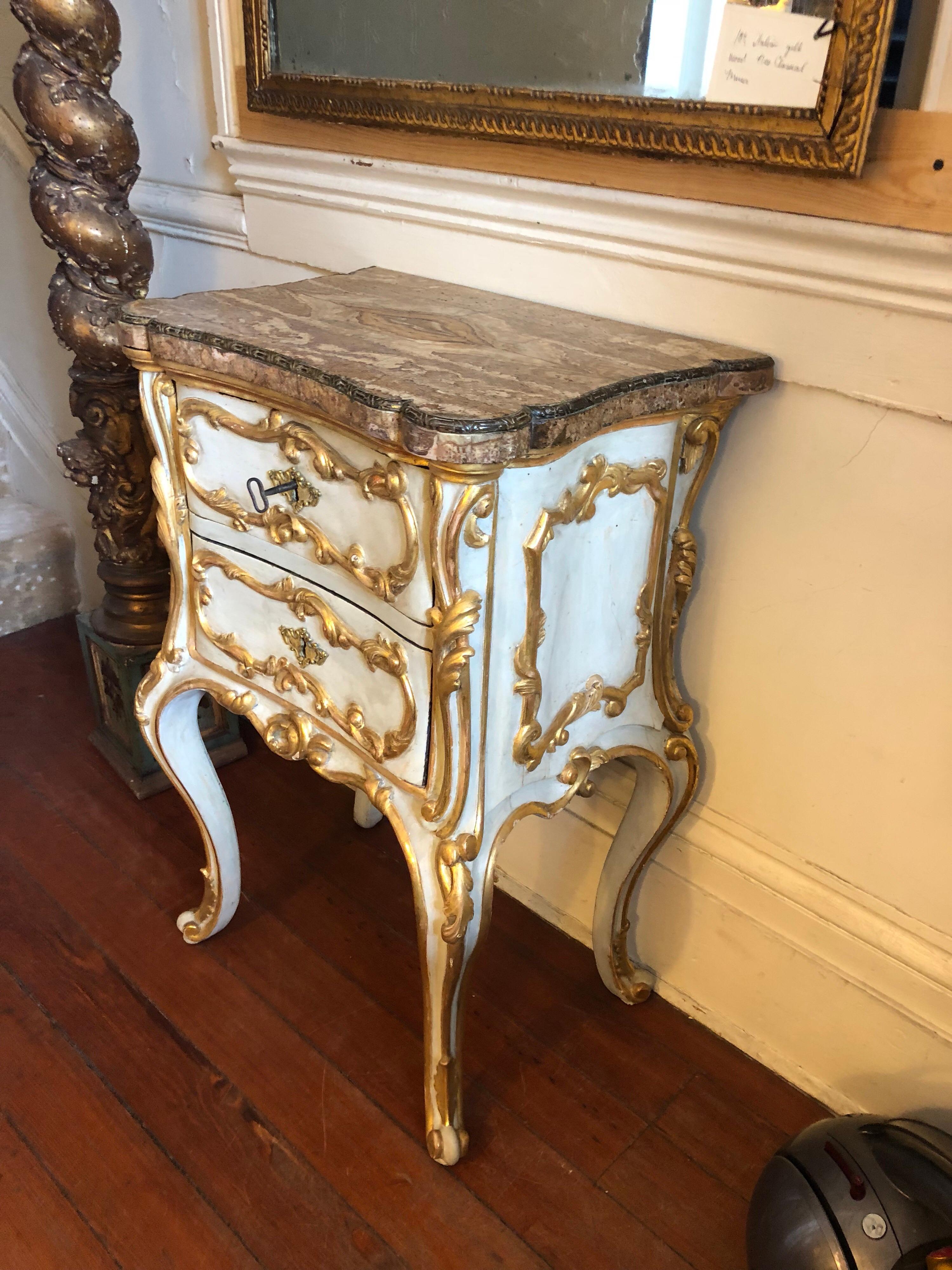 Italian Baroque painted and parcel-gilt commodini with bronze inlaid onyx top. From a roman noble family. This commodini is exceptional quality. The top is bookmatched with bronze inlaid trim. Case has two drawers on cabriole legs.
 