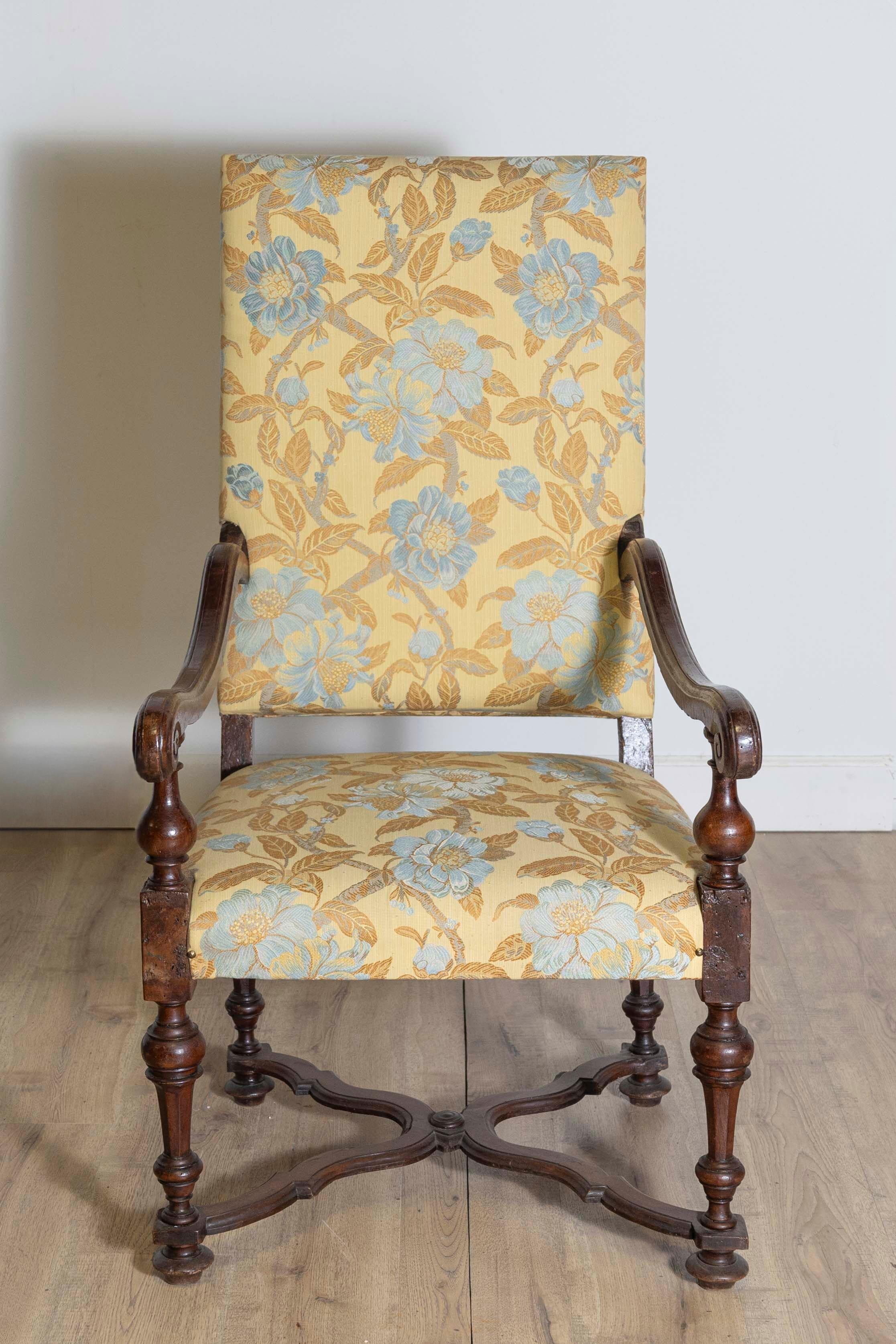 Fauteuil en noyer d'époque baroque italienne, datant du XVIIe siècle, avec dossier incliné, grands bras à enroulement, pieds tournés et traverse en forme de X sculptée. Ce fauteuil en noyer d'époque baroque italienne, originaire du XVIIe siècle, est