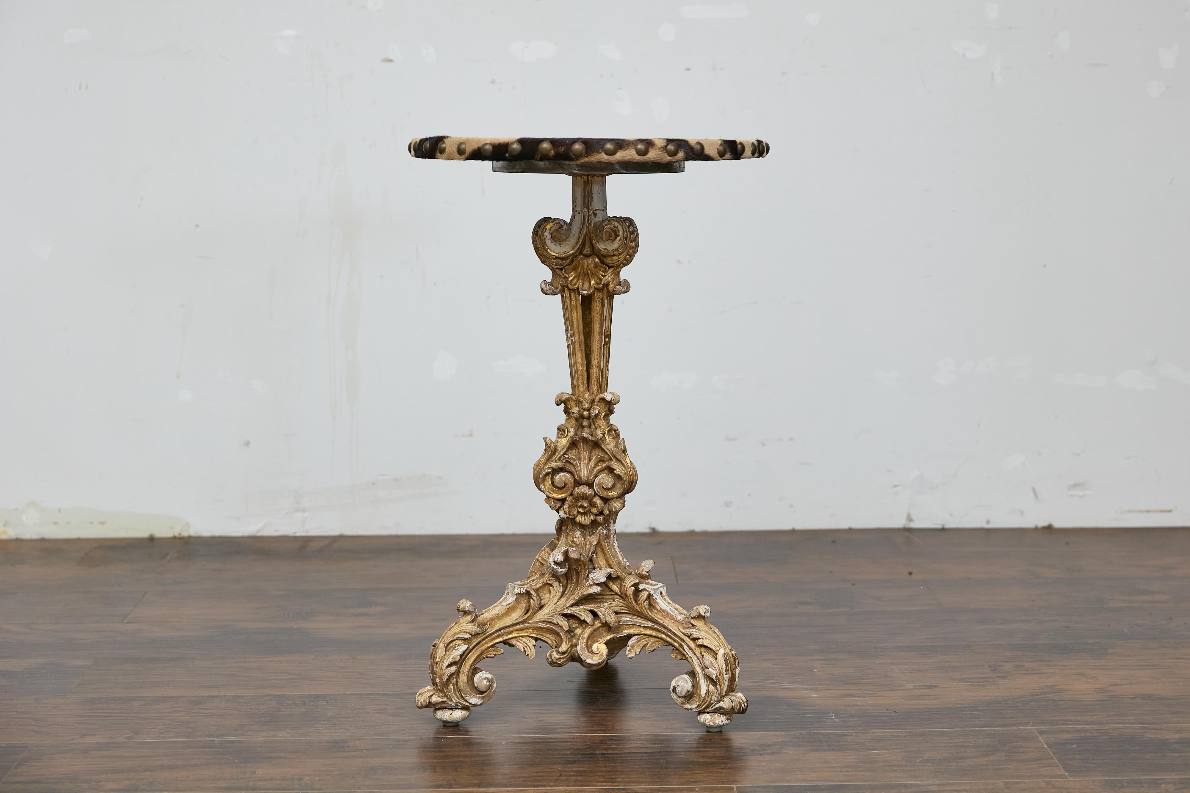 An Italian Baroque Revival period accent table from the 19th century with carved gilded base and zebra top. This exceptional 19th-century Italian table showcases intricate Baroque Revival artistry with its carved, gilded wood base and a striking