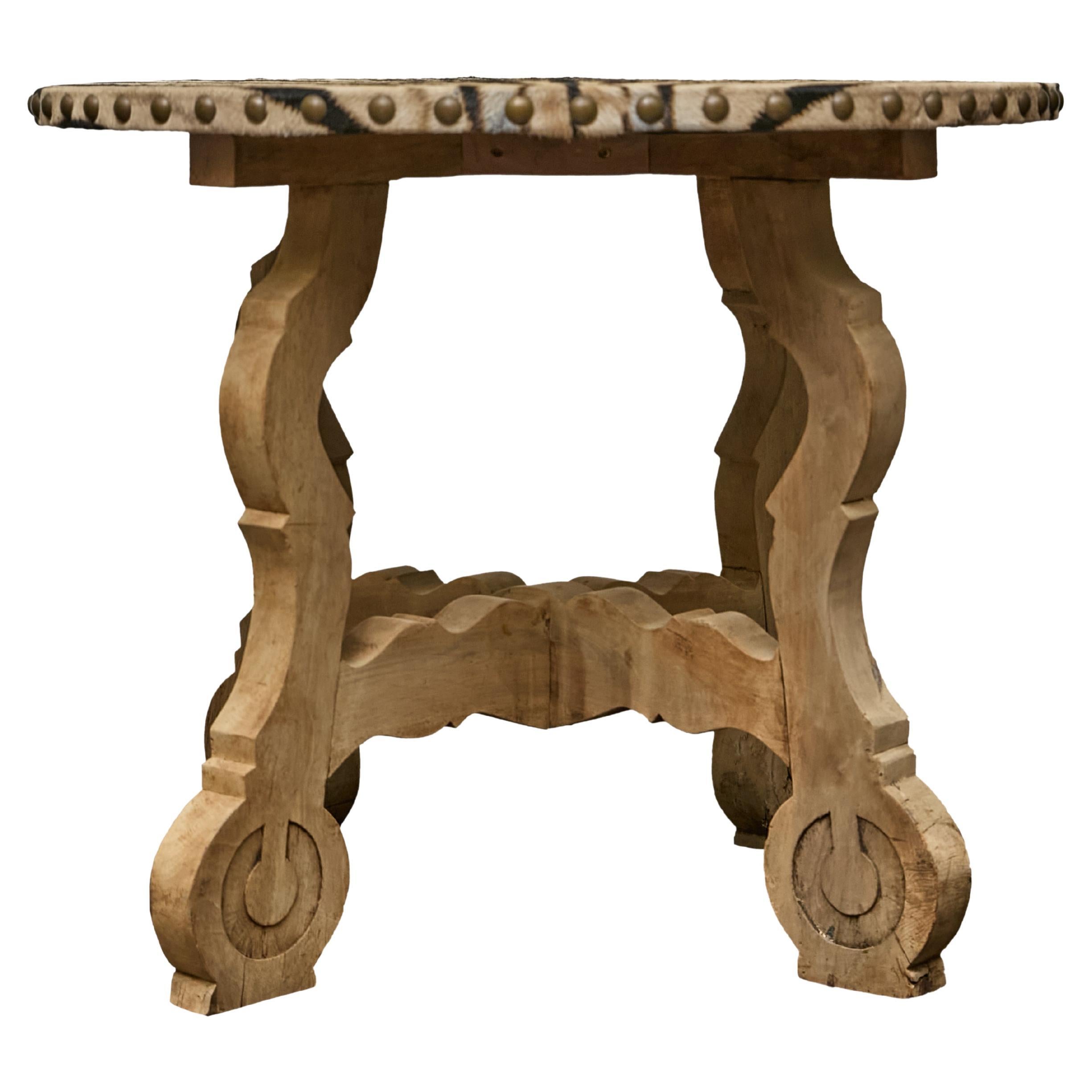 An Italian Baroque Revival 19th century walnut center table with zebra hide top. This 19th-century Italian center table showcases a masterful balance of bold craftsmanship and refined elegance. Made of solid walnut, the table has been treated to