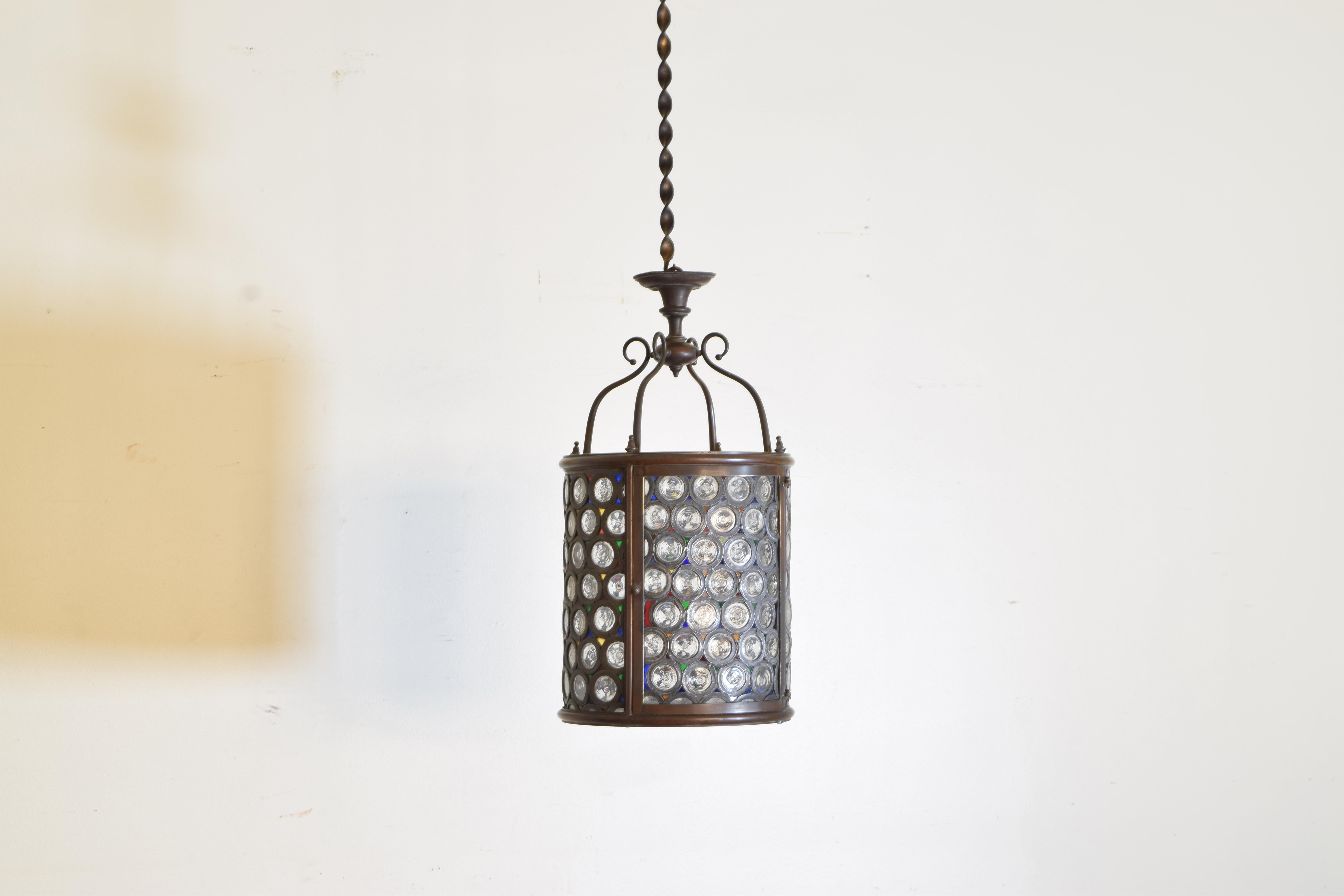From the second half of the 19th century this circular lantern has a frame constructed of patinated brass with one hinged door, the surfaces all composed of circular colored discs within lead framework, currently unwired but can be wired to suit.