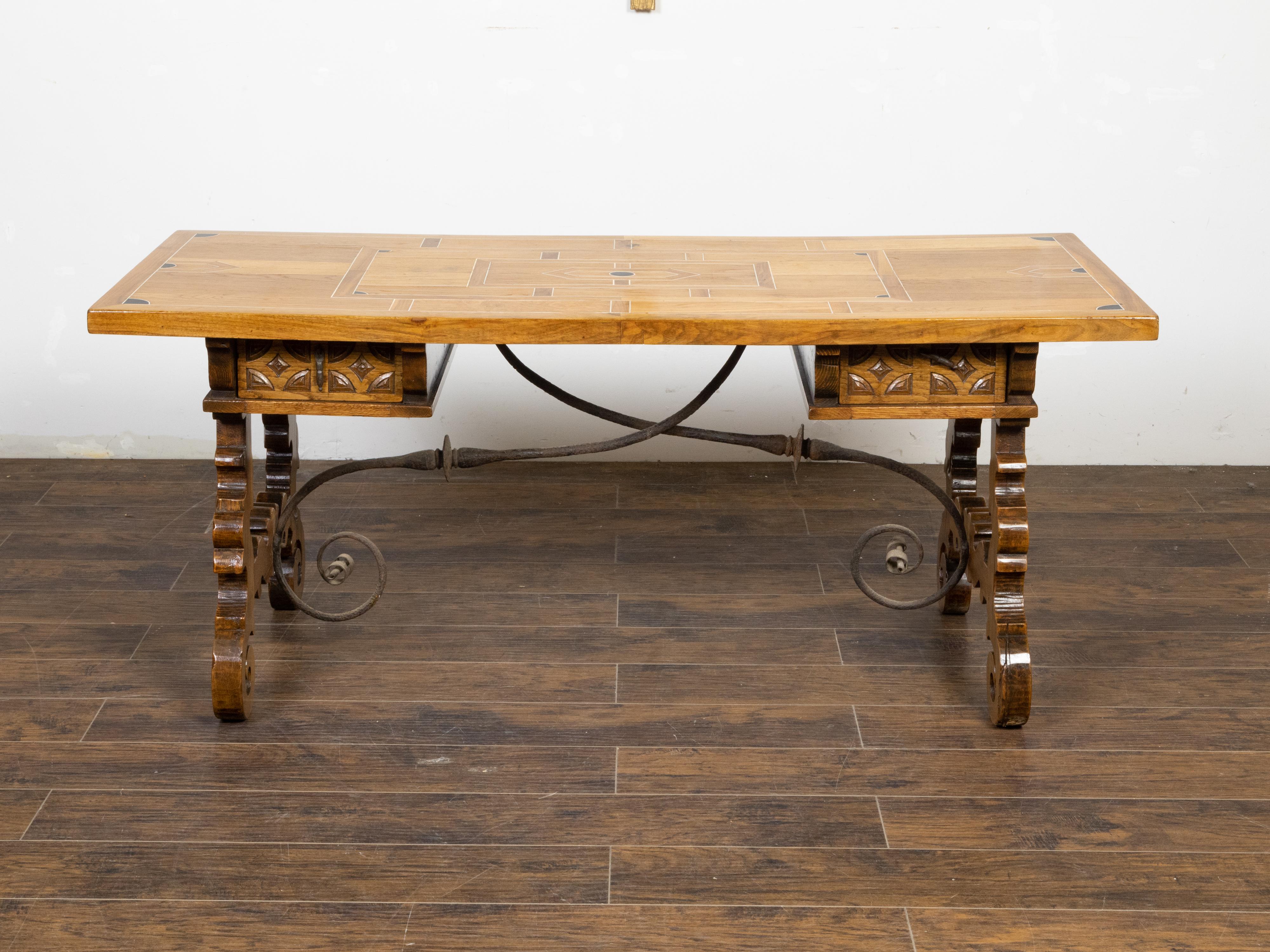 An Italian Baroque style walnut desk table from the late 19th century, with inlaid top, two drawers, lyre-shaped legs and iron stretchers. Created in Italy during the last quarter of the 19th century, this walnut table features an unusual top inlaid