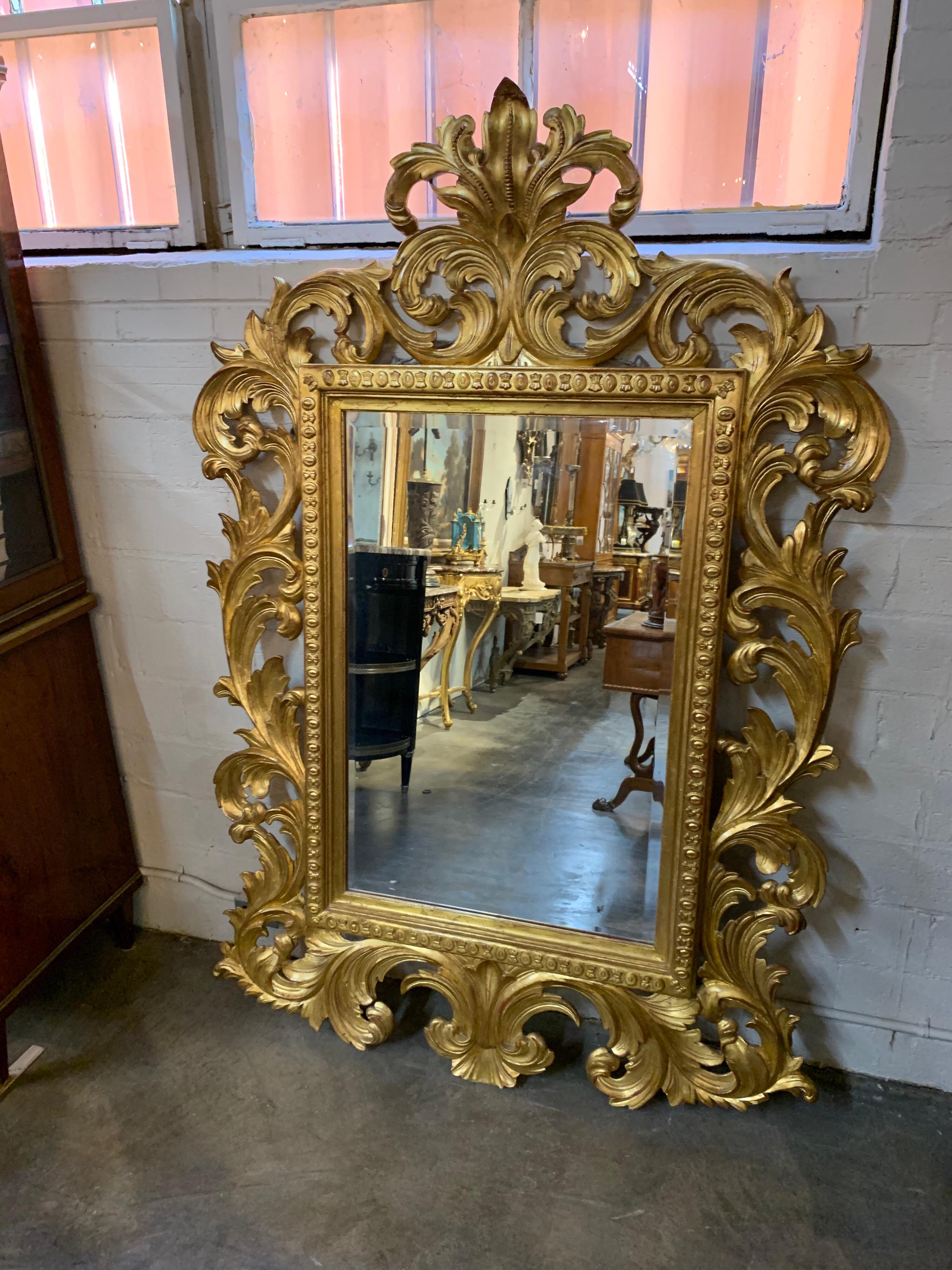 Very elegant large scale Italian Baroque style carved and gold gilt mirror. Great scrolling pattern creates a dramatic and impressive effect.