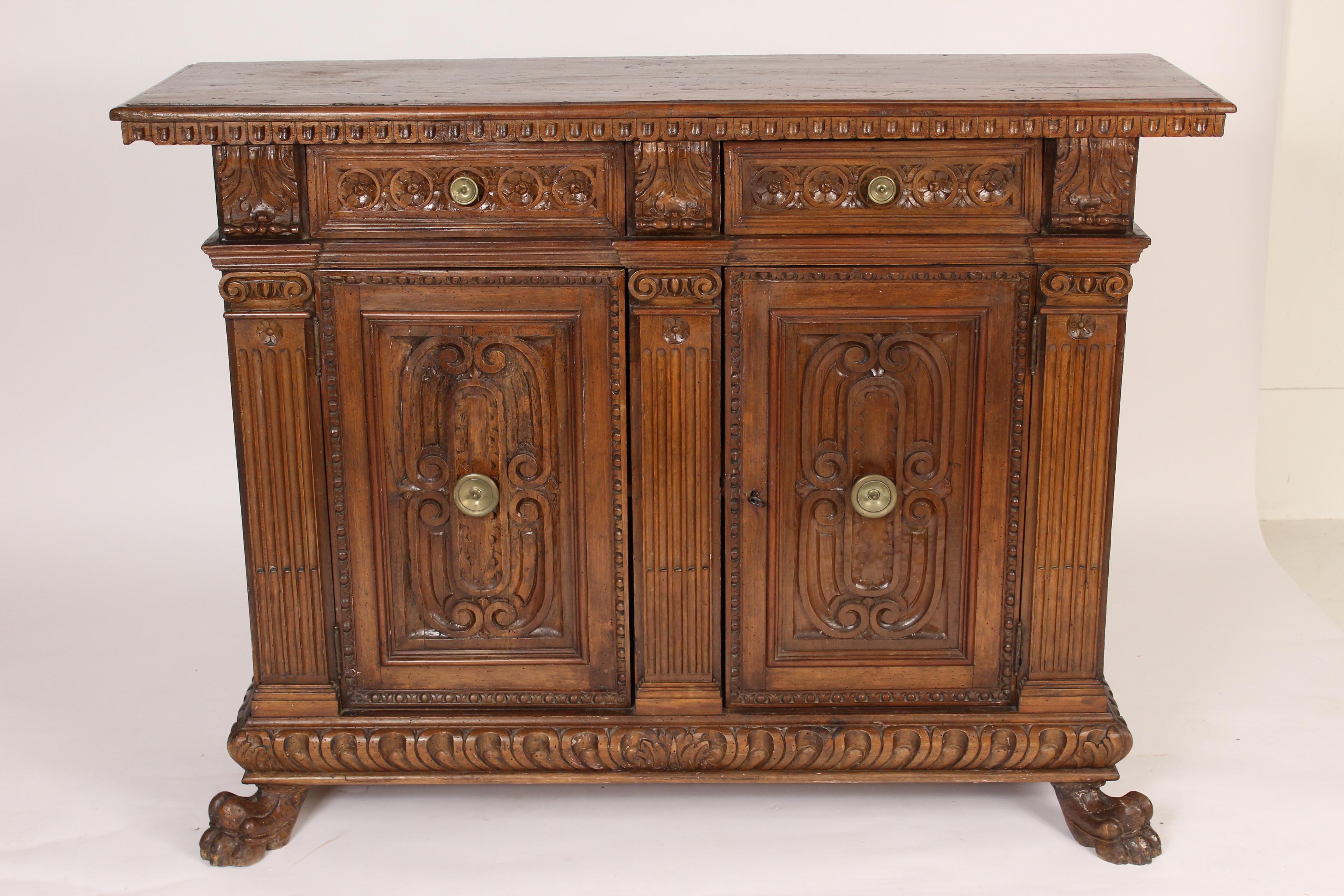 Italian Baroque style beech wood and walnut credenza, made from antique and later elements. Assembled, circa 1950s. With acanthus leaf carvings, dental moldings, rosette carvings, ionic capitals atop fluted columns and well defined paw feet. Inside