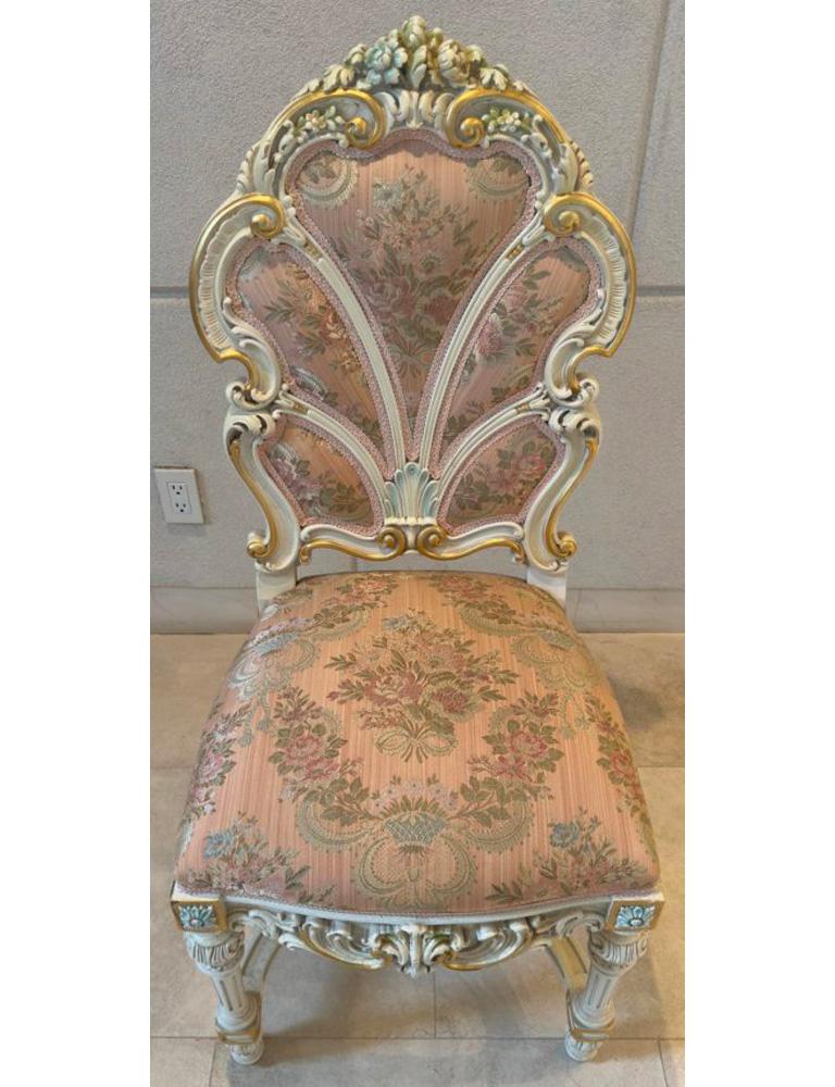 A set of 14 Italian Baroque style dining chairs, each meticulously crafted to epitomize opulence and sophistication. Delicately finished in antiqued white, adorned with subtle pastel hues and accents of radiant gold, these chairs exude an air of