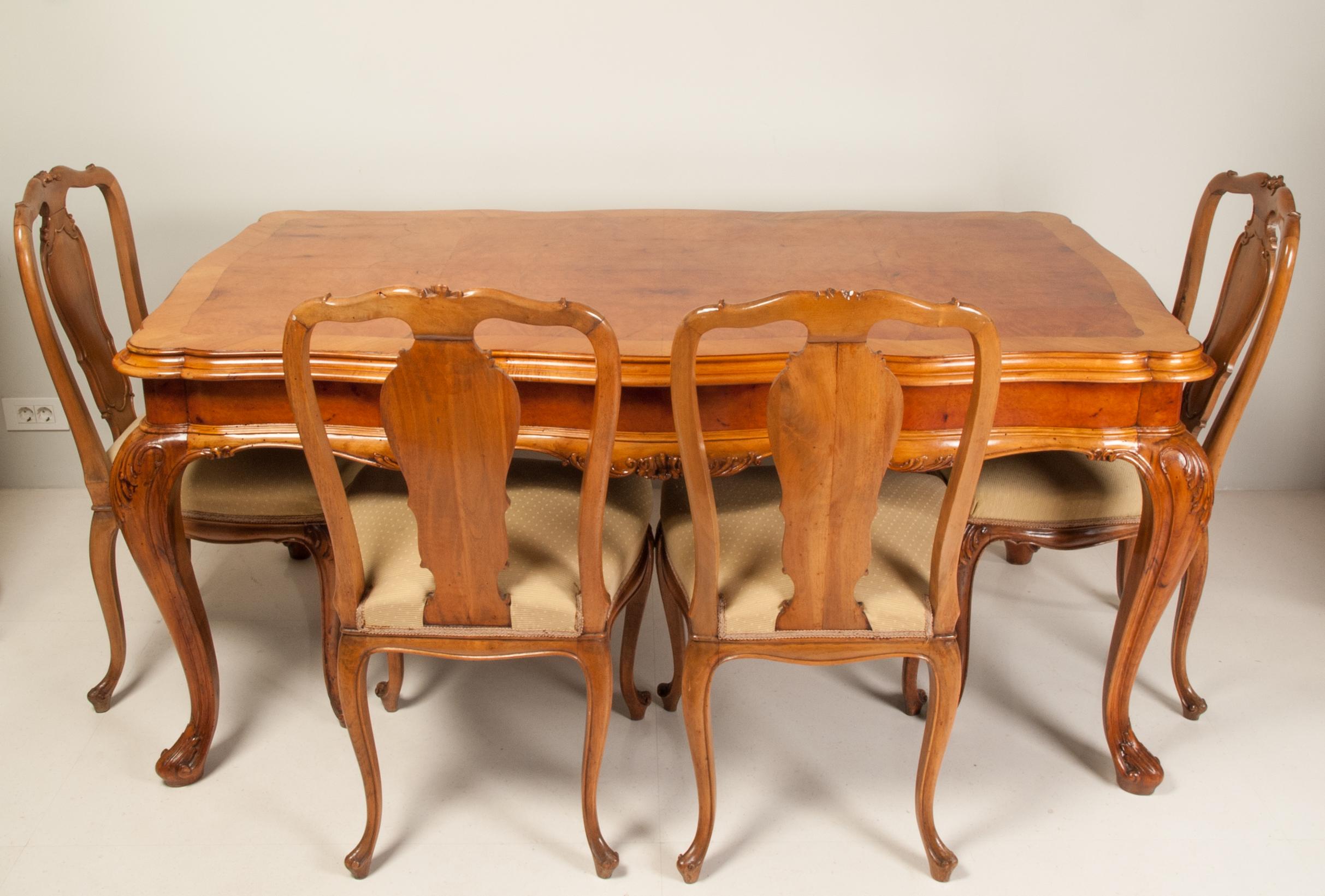 Large and massive early 20th century extendable walnut and poplar root veneer dining table. Below the top are two pull-out drawers to which additional boards are laid on. Ornate frame over four cabriole legs. Each of the legs being carved at the