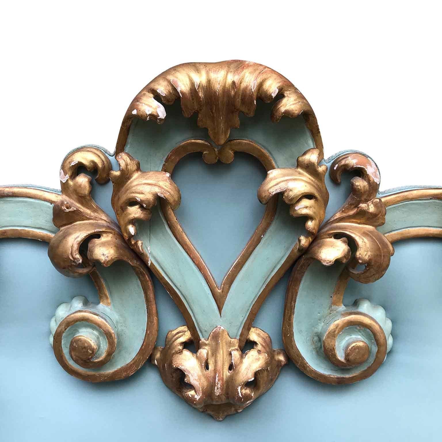 Italian 20th century Baroque style decorative gilt elements mounted onto an upholstered headboard. The headboard fits a double bed and displays a lovely hand carved wooden frame with scrolled foliate movements, original gold-leaf gilding and
