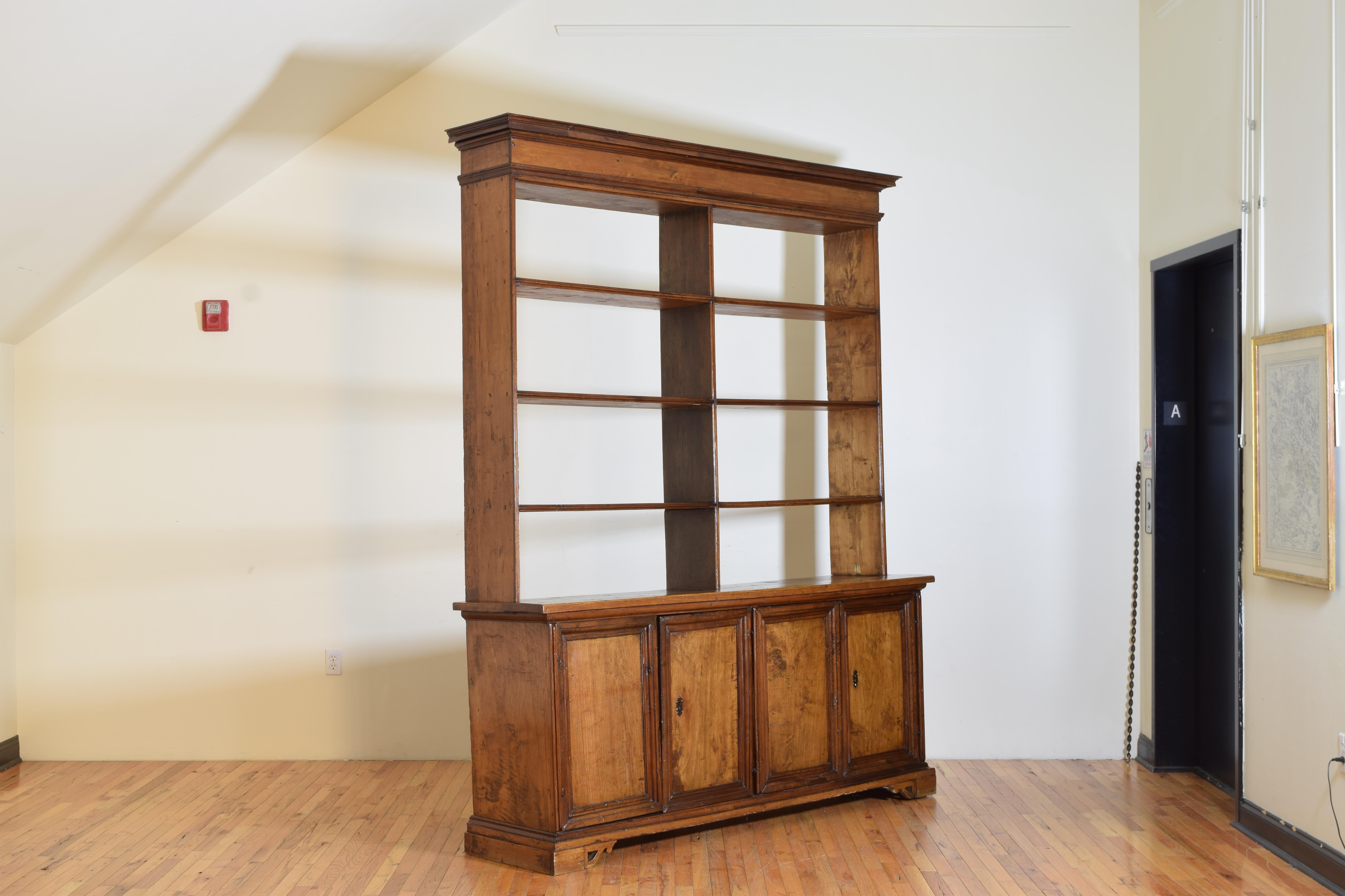 Having a stepped cornice and accompanying lower molding on the upper (later) bookcase section which houses 4 levels of shelves, the lower section is a credenza with four doors opening to reveal interior shelving, both sides with working locks,