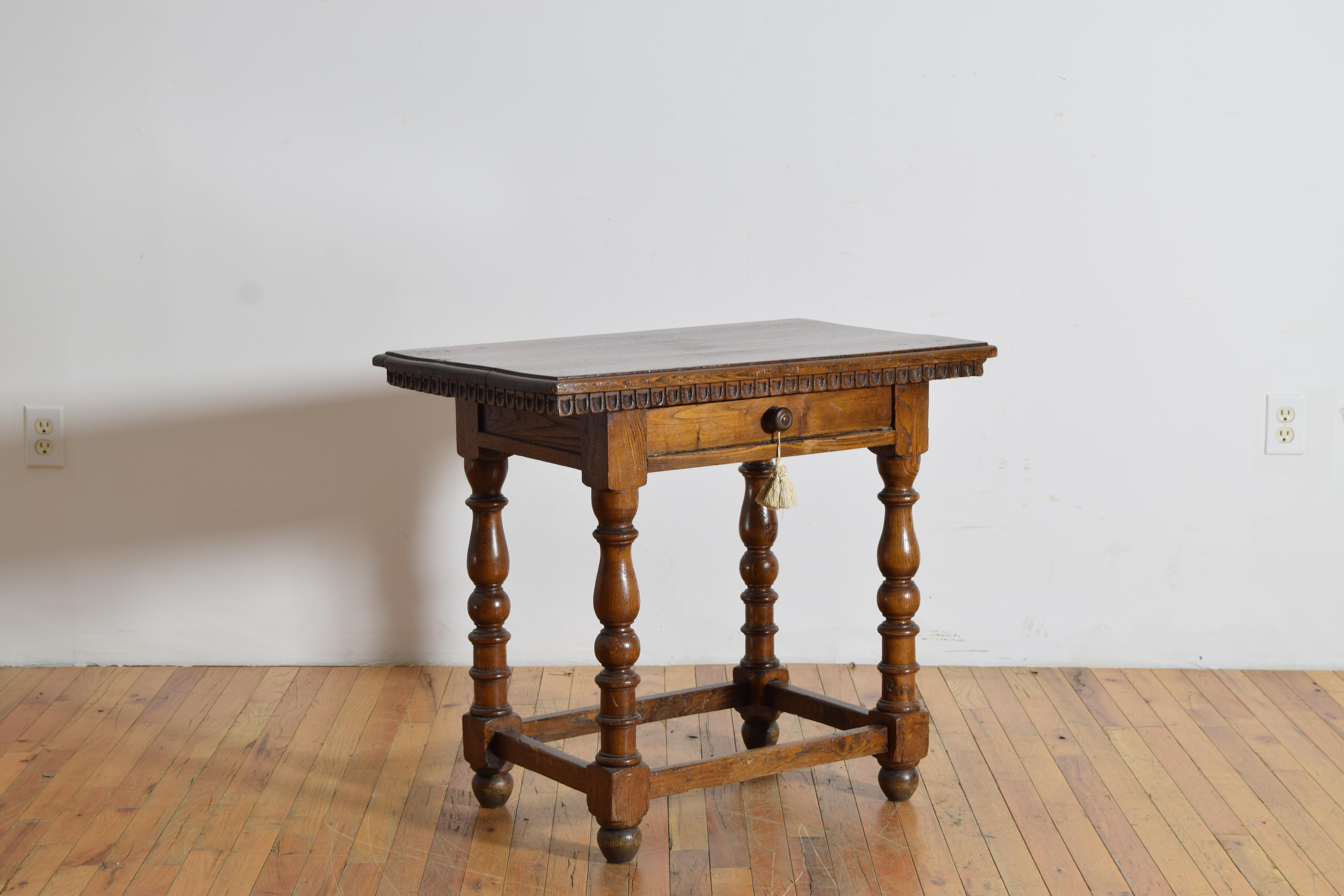 Il piano è rettangolare con bordi modanati e grembiule intagliato a forma di gadroon, mentre la cassa conforme ospita un cassetto; la cassa è sollevata da gambe tornite unite da una barella.