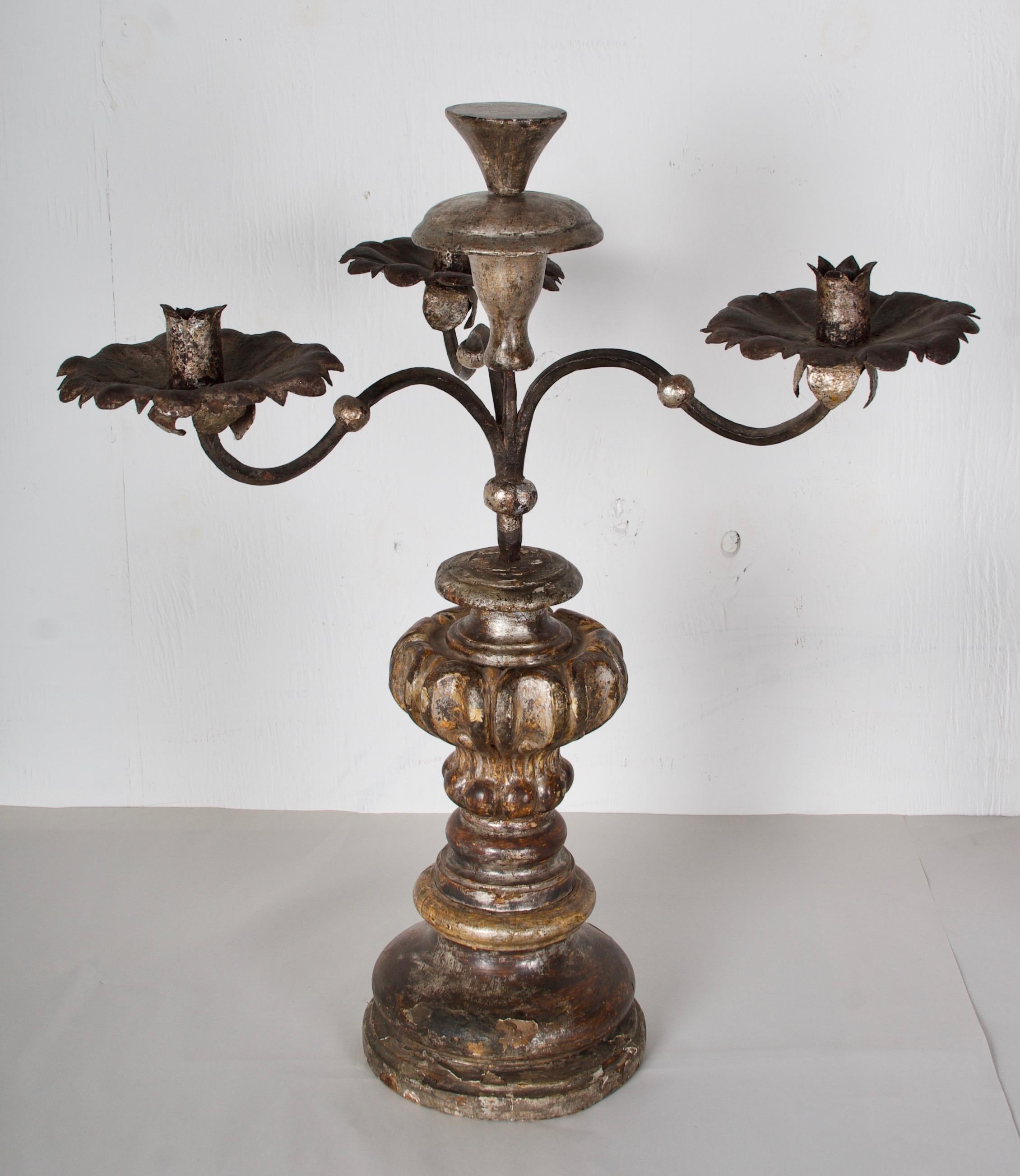 A wonderful pair of hand carved and gilded torcheres with handwrought iron
candle arms and bobeches. The candelabra portion lifts out of the wood base.
The base once was gilded in white gold, the ochre colored boule peaks thru the
traces of white